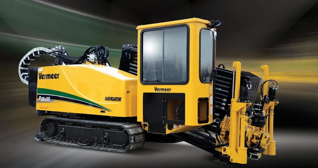 Yellow Vermeer NAVIGATOR D36x50DR horizontal directional drill with black tracks and a large control cabin, on a blurred background