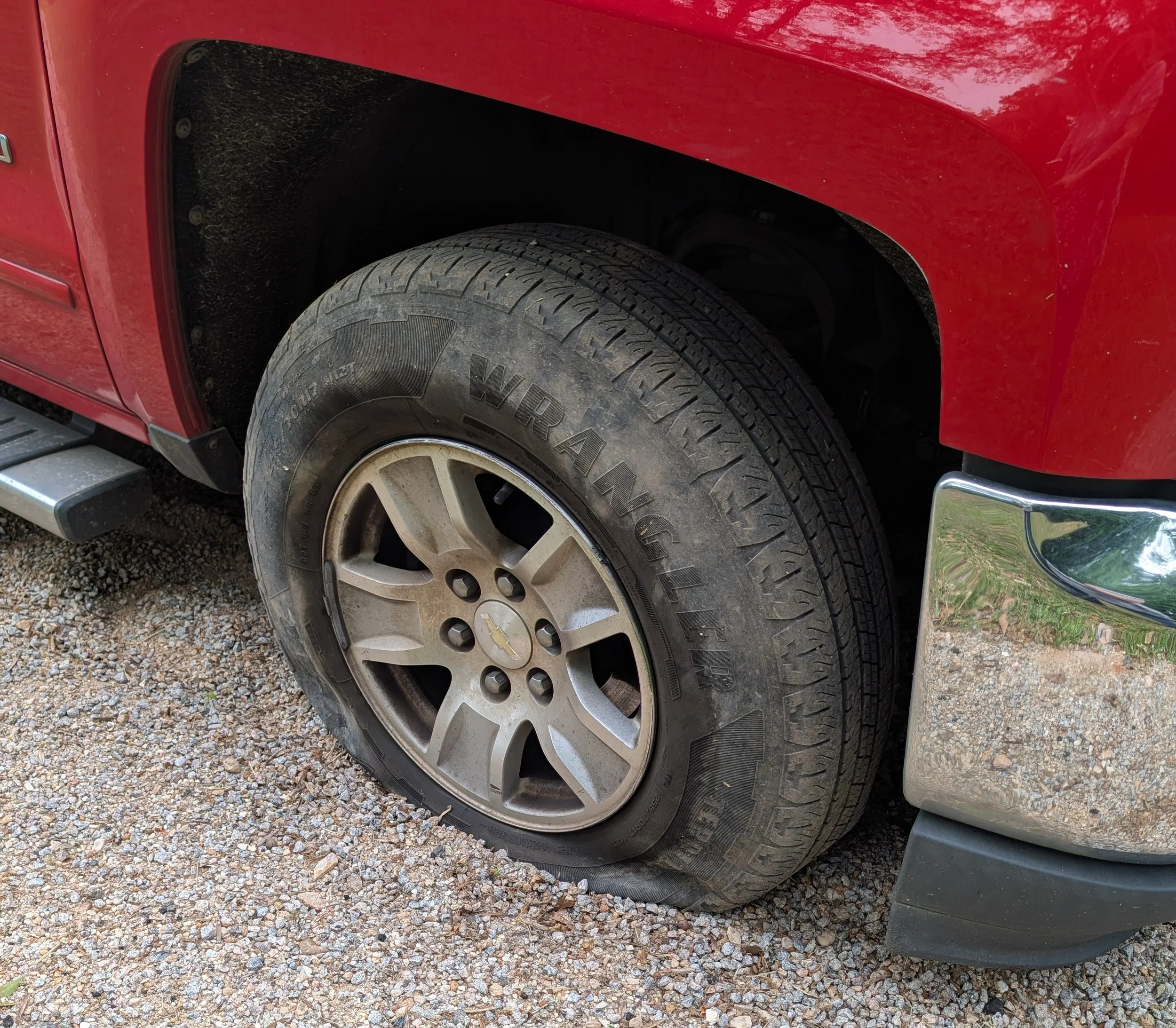 A close up of a very flat tire on a vehicle.
