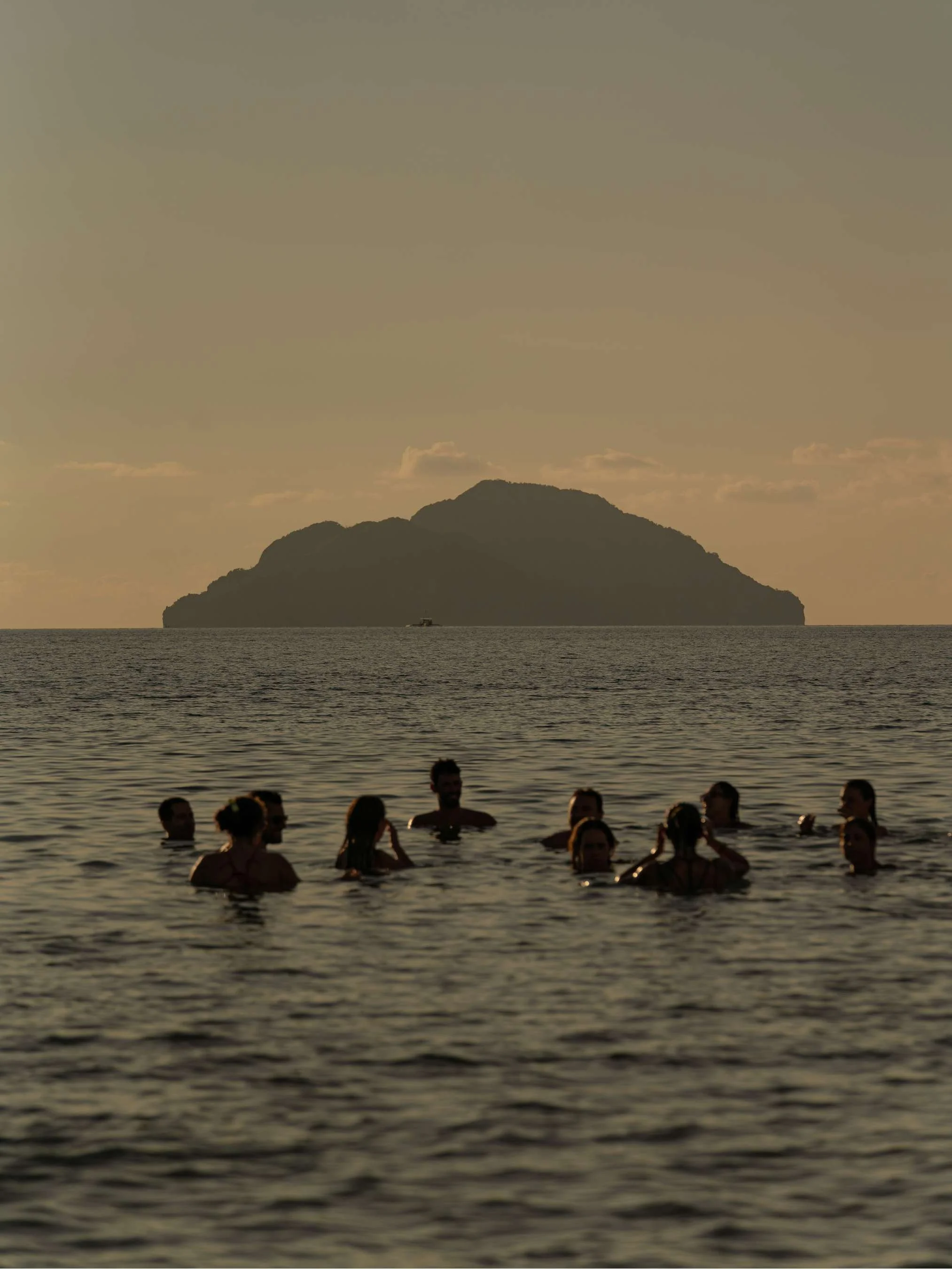 People swimming in the ocean at sunset, Landscape photography, Island Beach, Sunset at Lio Beach in El Nido, Philippines 