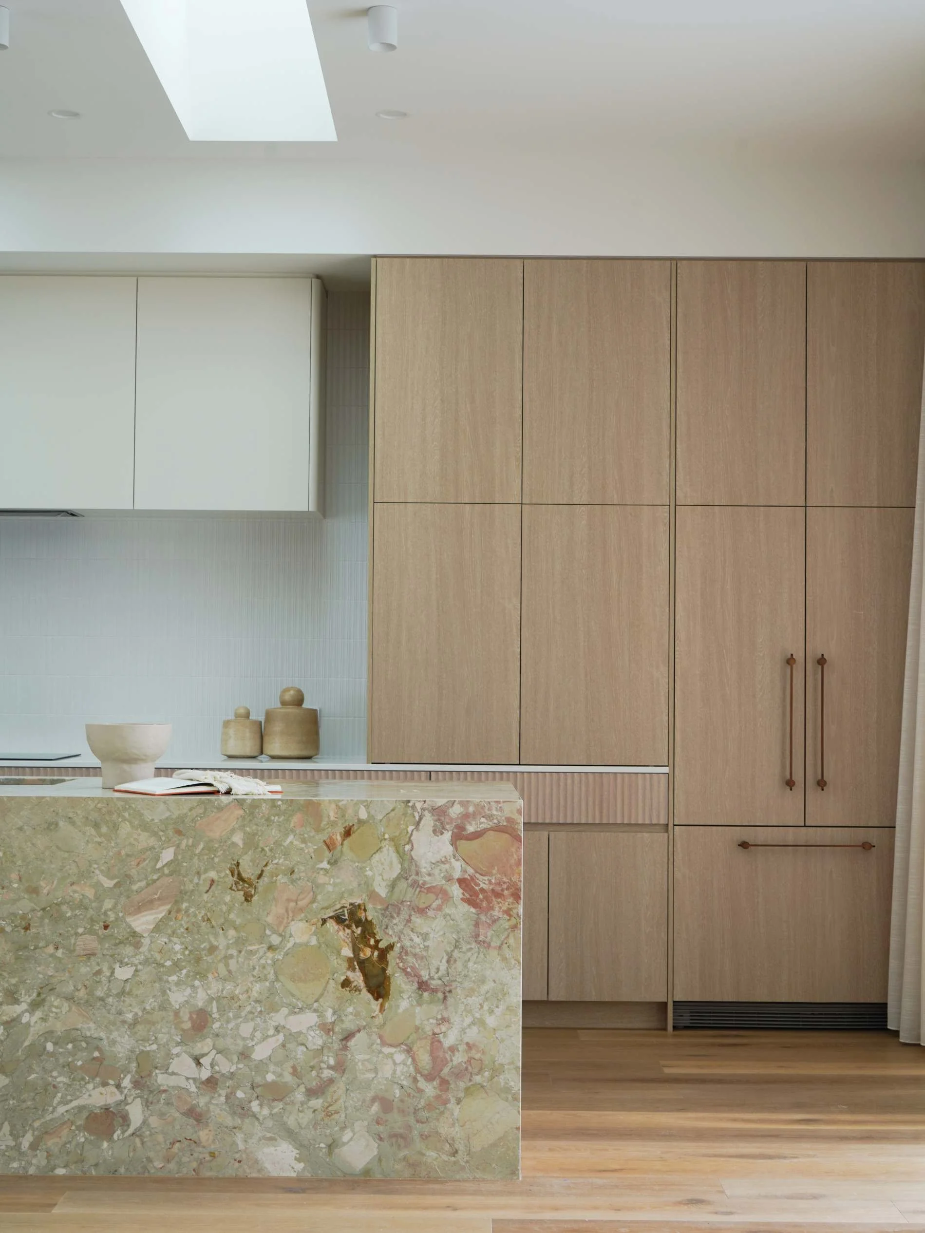 Mid Century Palm Springs Modern kitchen with beige cabinetry, a marble island with pink, beige, and brown tones, and a light wooden floor in honeyeater drive burleigh waters