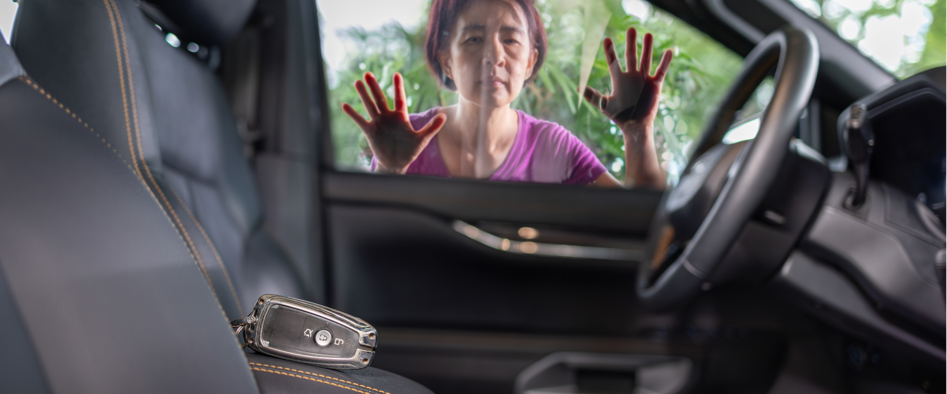 A woman wearing a pink shirt presses her hands against the outside of a car window, looking inside from outside the vehicle.