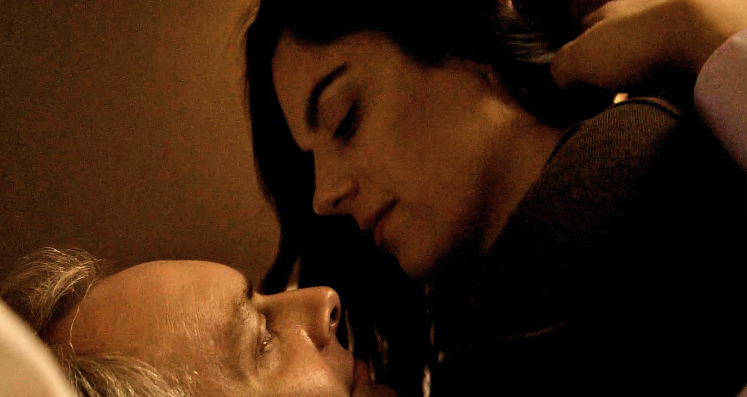 Movie still from the short film Meet Me There - a man and woman's faces sharing and intimate moment