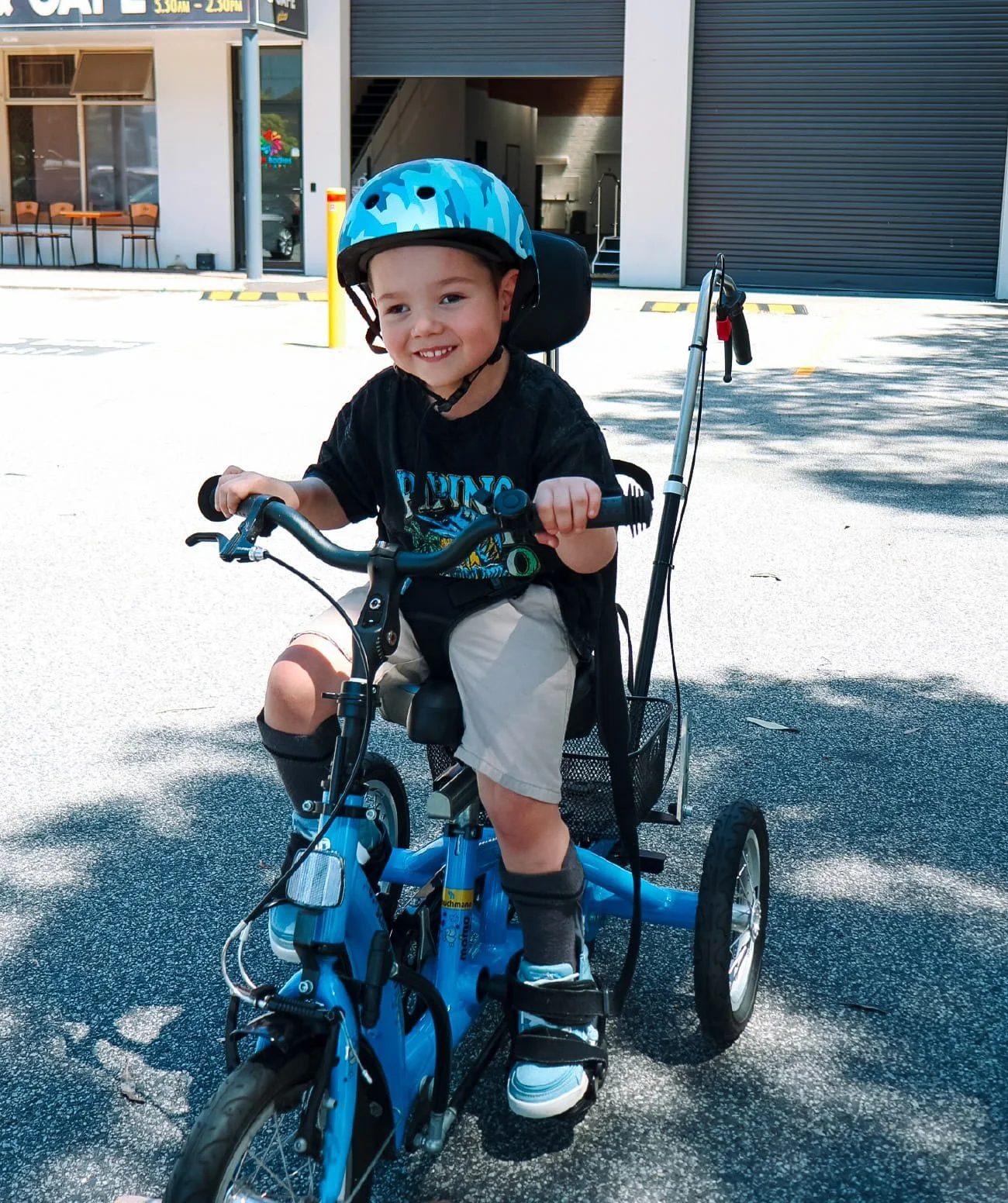 Child smiling as they try out adaptive equipment to support their functional movement and participation