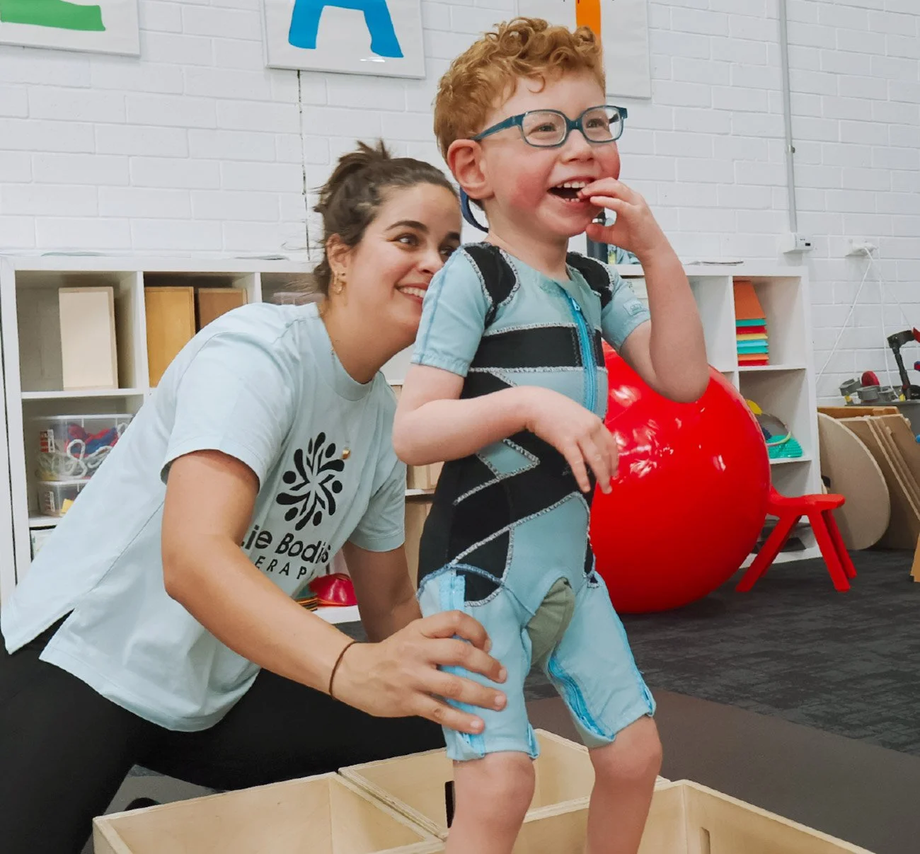 Child participating in a goal-based physiotherapy activity with support from a paediatric physiotherapist