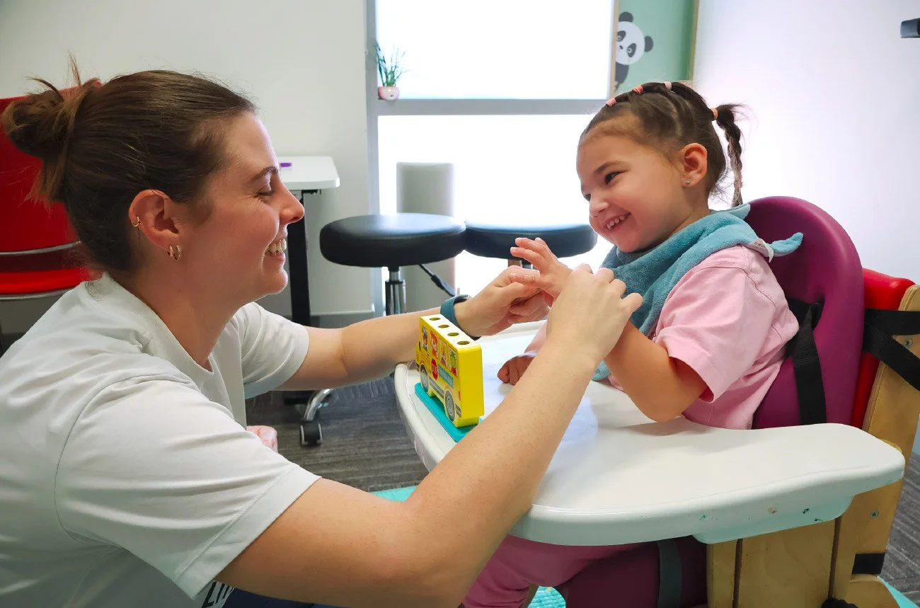 Therapist assisting child with fine motor developmental movement tasks