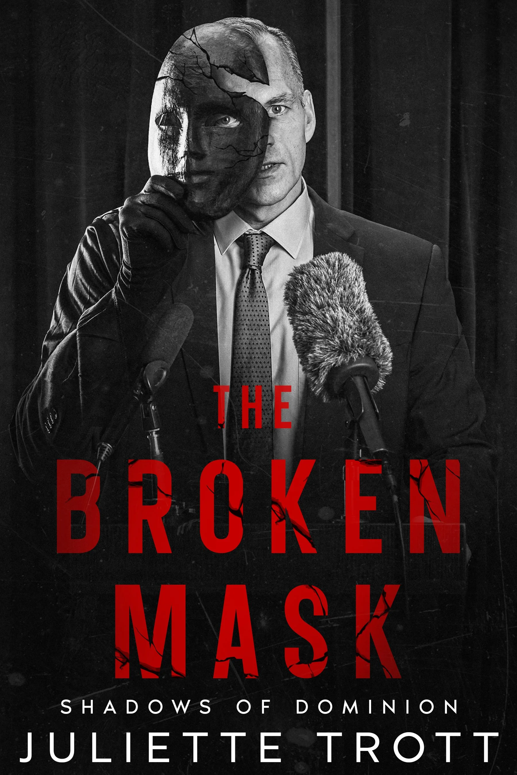 A man in a suit holding a cracked, half-mask of a face, with the left side cracked and damaged, while the right side shows his real face. The background is dark. The title reads "The Broken Mask" in bold red letters, with the subtitle "Shadows of Dominion" and the author's name "Juliette Trott" below.