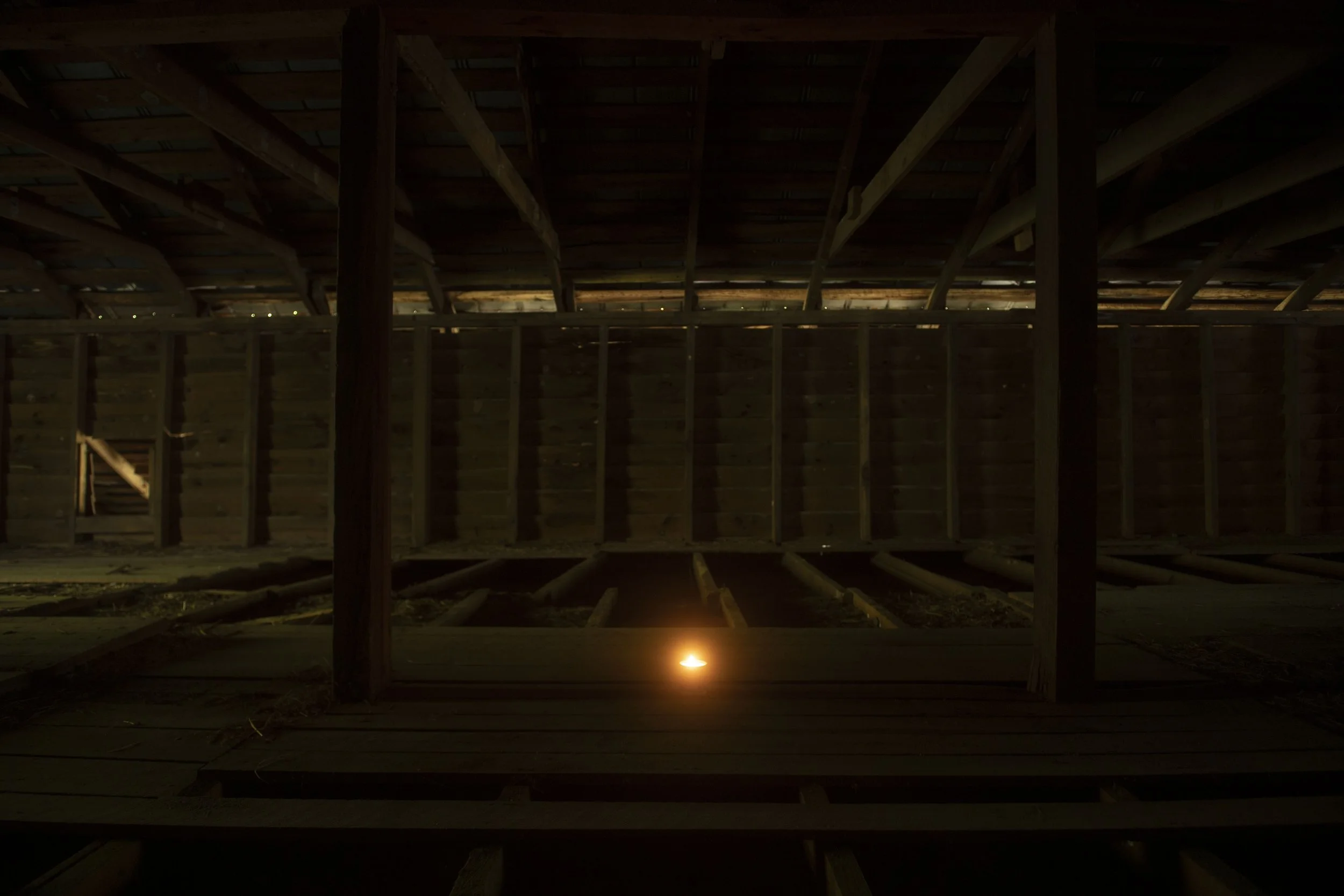 Candle glowing in a deserted barn, Rockefeller property in North Carolina.