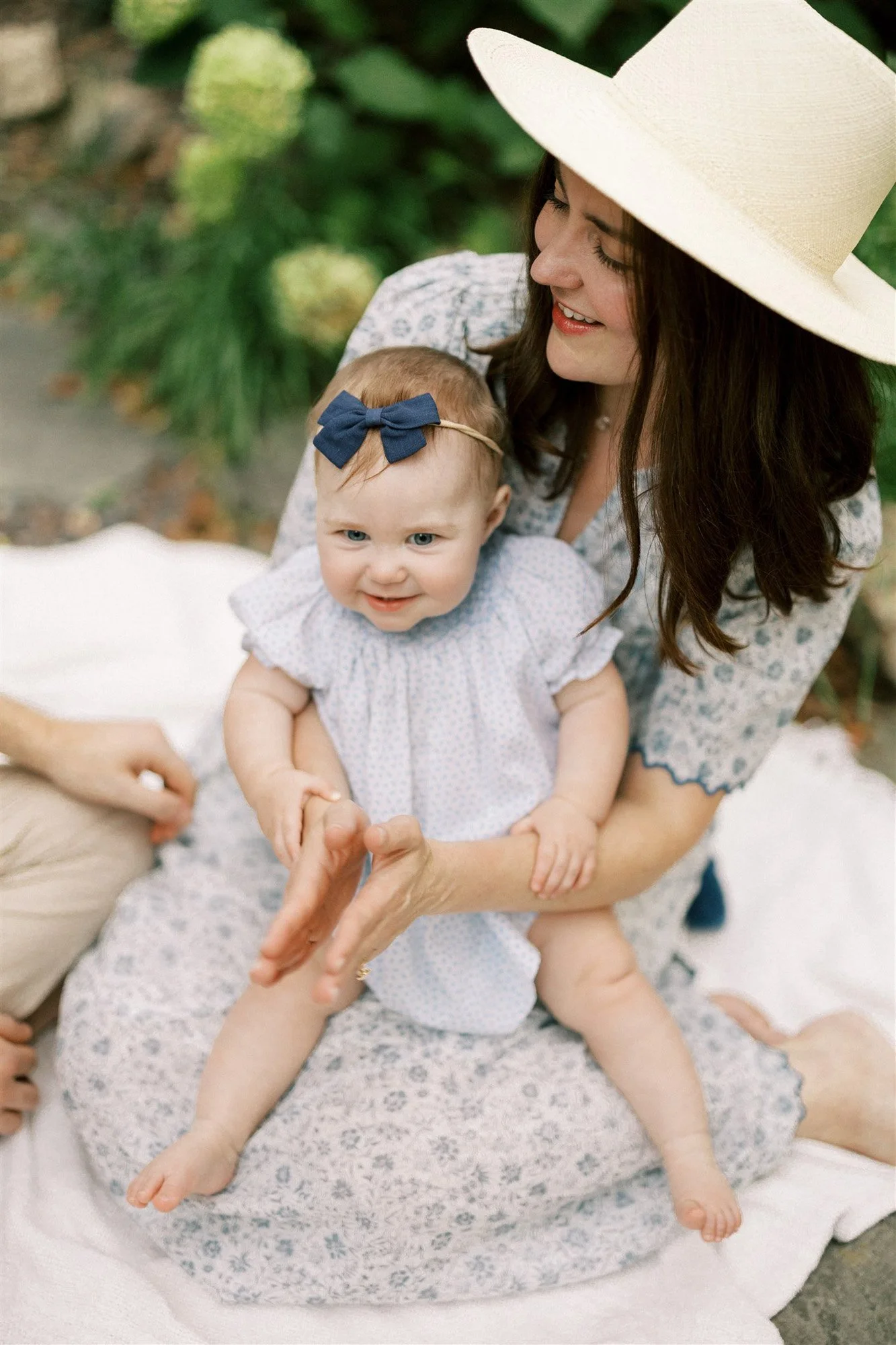Mom holding daughter on lap in park