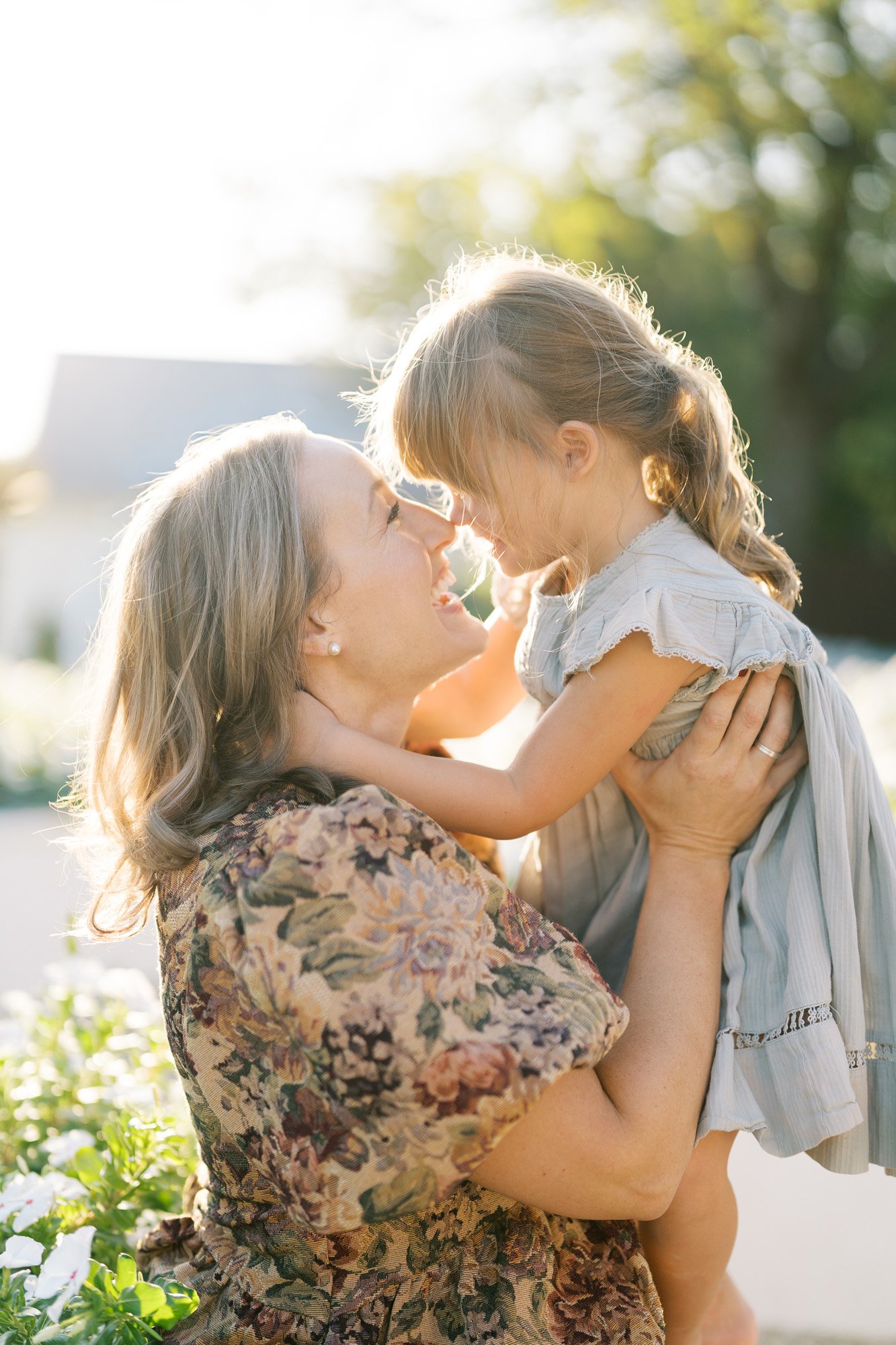 Mom and daughter rubbing noses in beautiful outdoor light