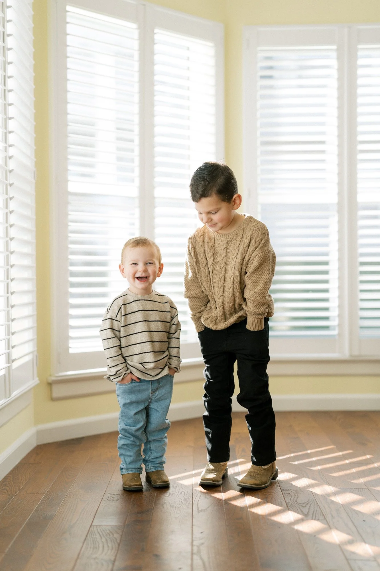 Tristan's boys at home, hands in pockets of jeans smiling