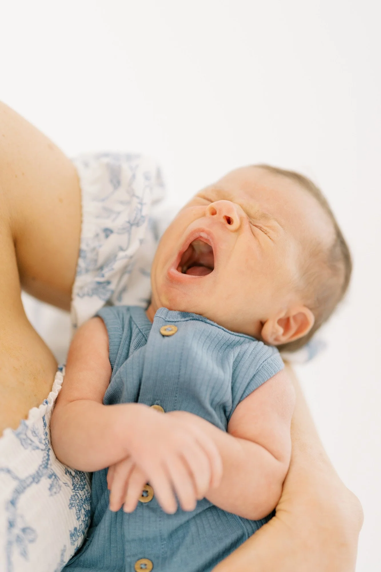 Newborn yawning in mom's arms