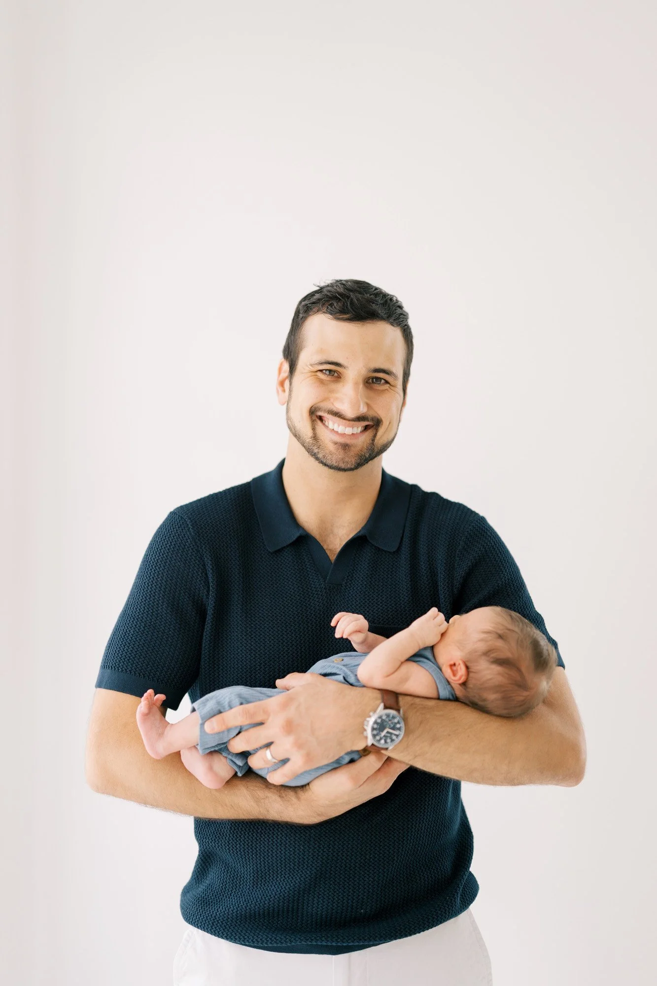 Dad smiling holding newborn