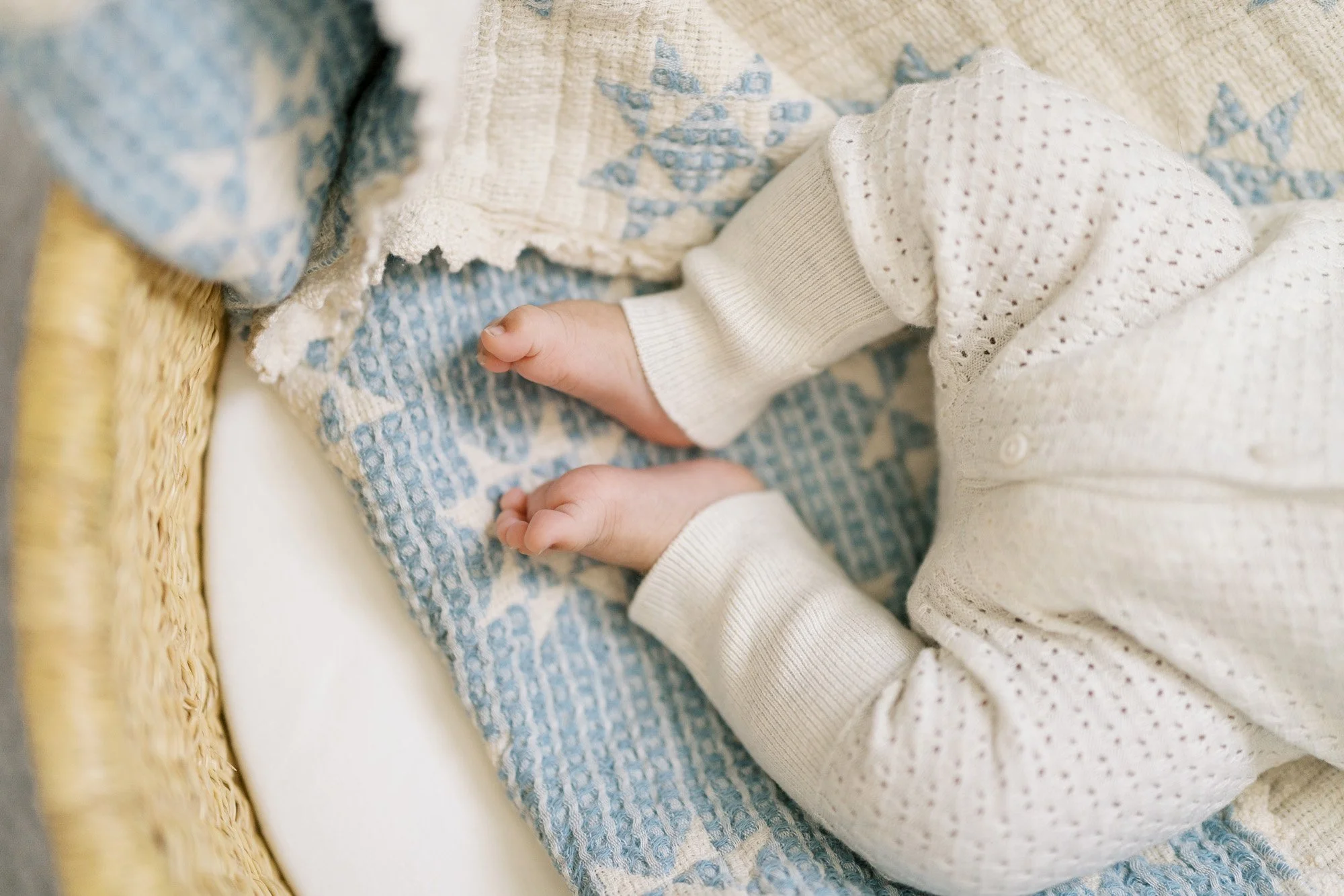 newborn feed in a knit onesie on a blue blanket in a photo studio