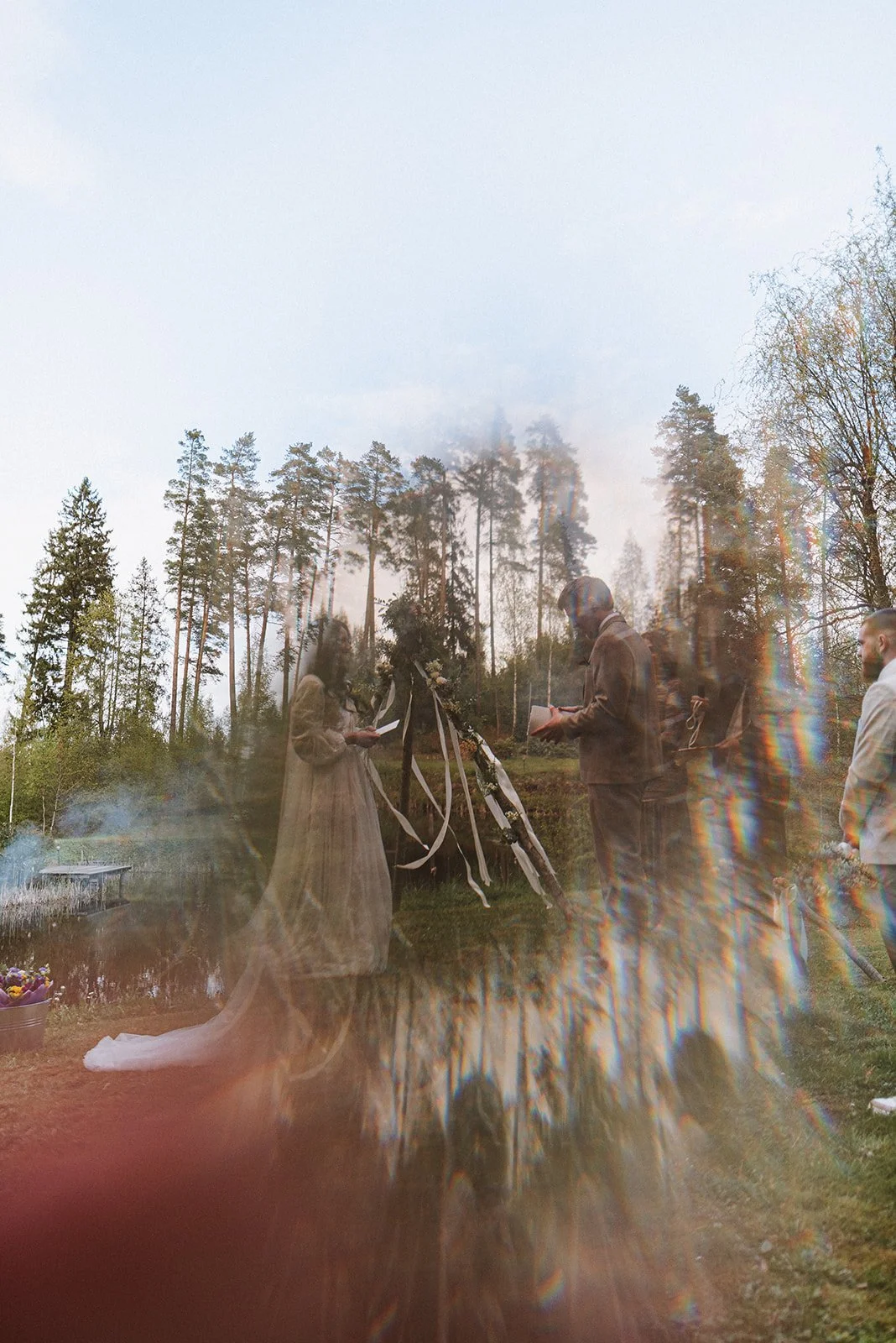 Kāzu ceremonijas vieta koku un gaismas ielenkumā.