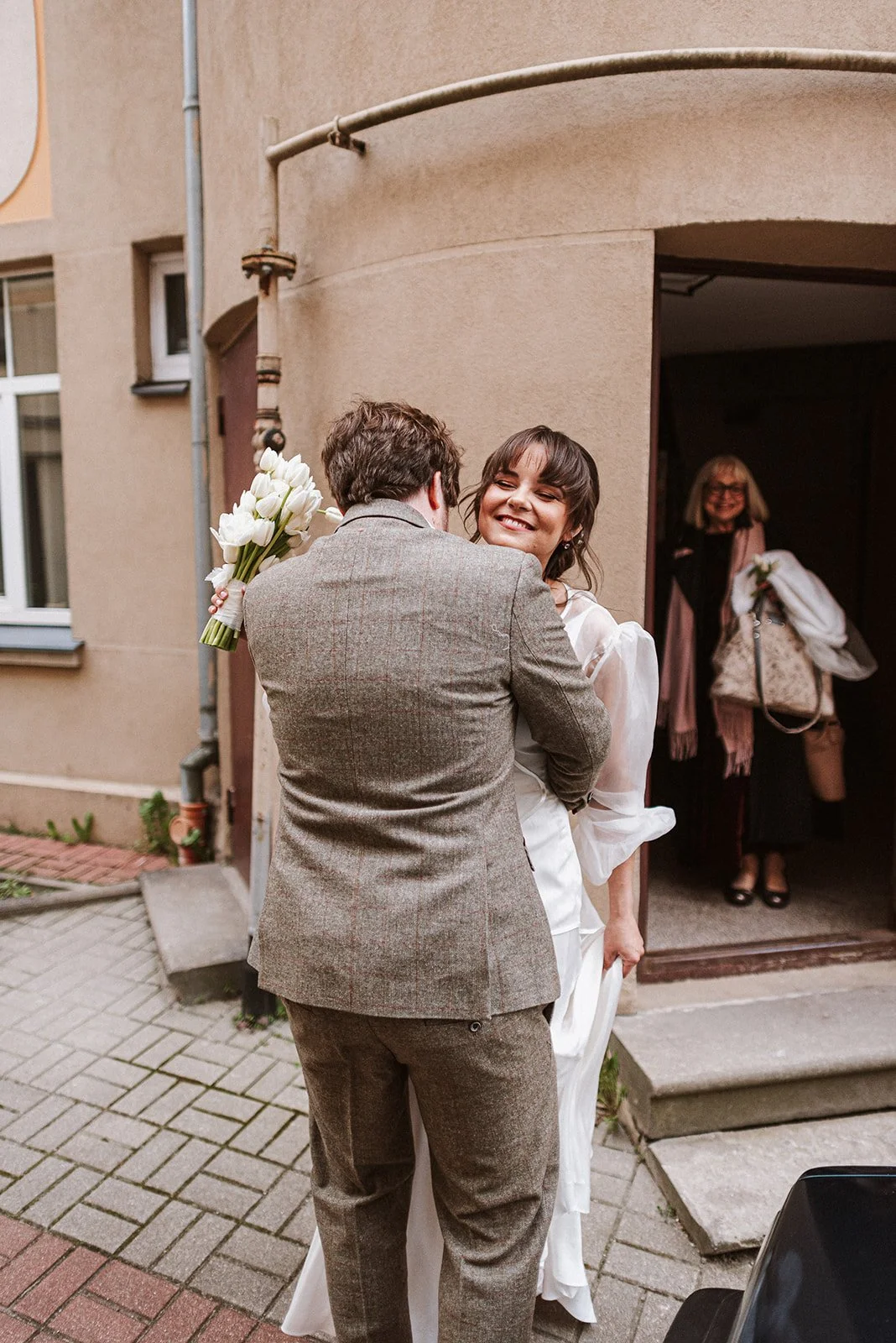 Kāzu pāris satiekas pie ēkas ieejas.