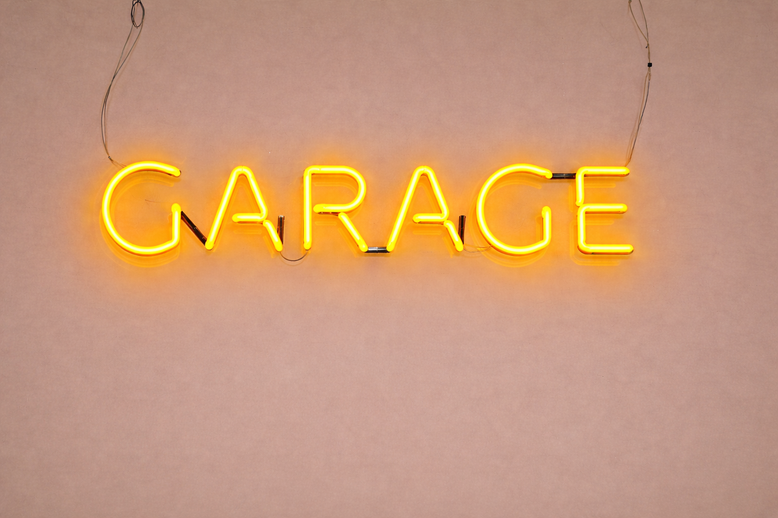 Neon-Schilder mit der Aufschrift »GARAGE« an einer Wand