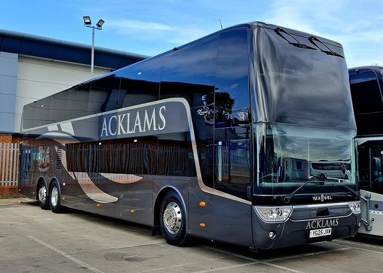 A double-decker black bus with the word