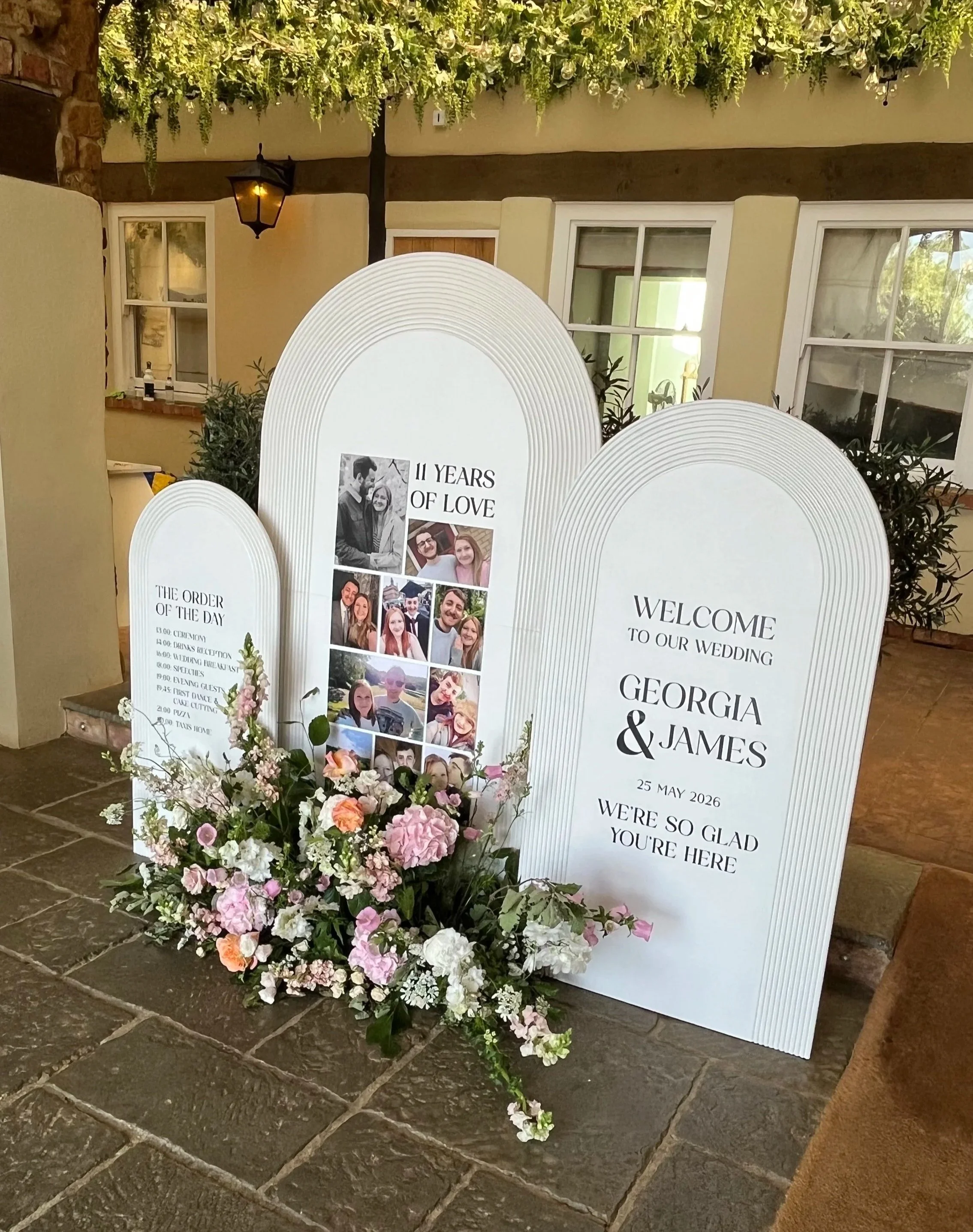 Statement wedding signage installation featuring personalised story boards, photographs and floral arrangements tailored to the couple's journey.