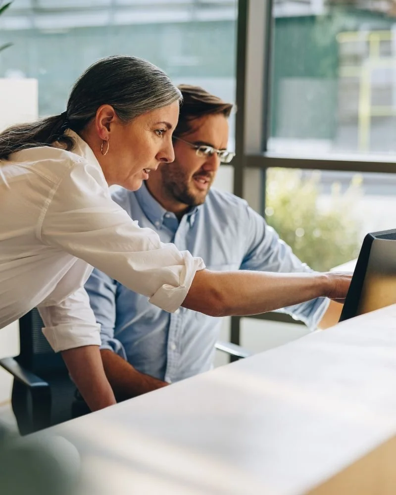 Seren Delta DIgital Transformation Services - Leanix as a Service. A woman and man working together at a desk, looking at a computer screen in a modern office with large windows.