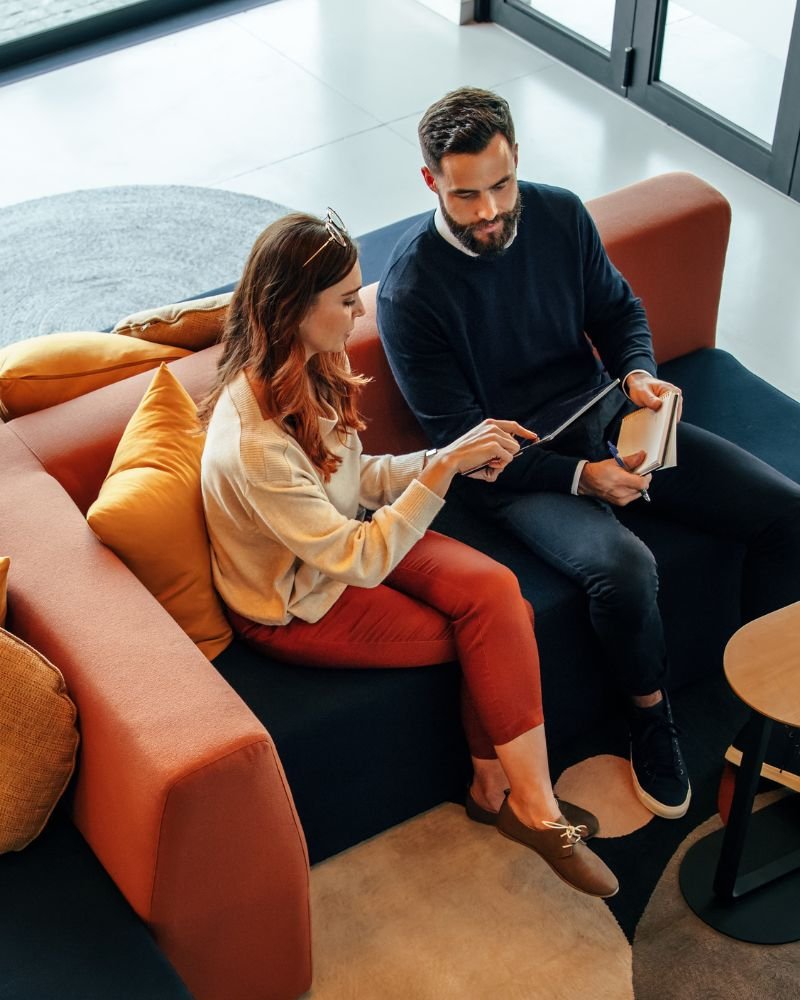 Seren Delta DIgital Transformation Services - Enterprise Architecture Insights. Two people sitting on a colorful modern sofa looking at a tablet.