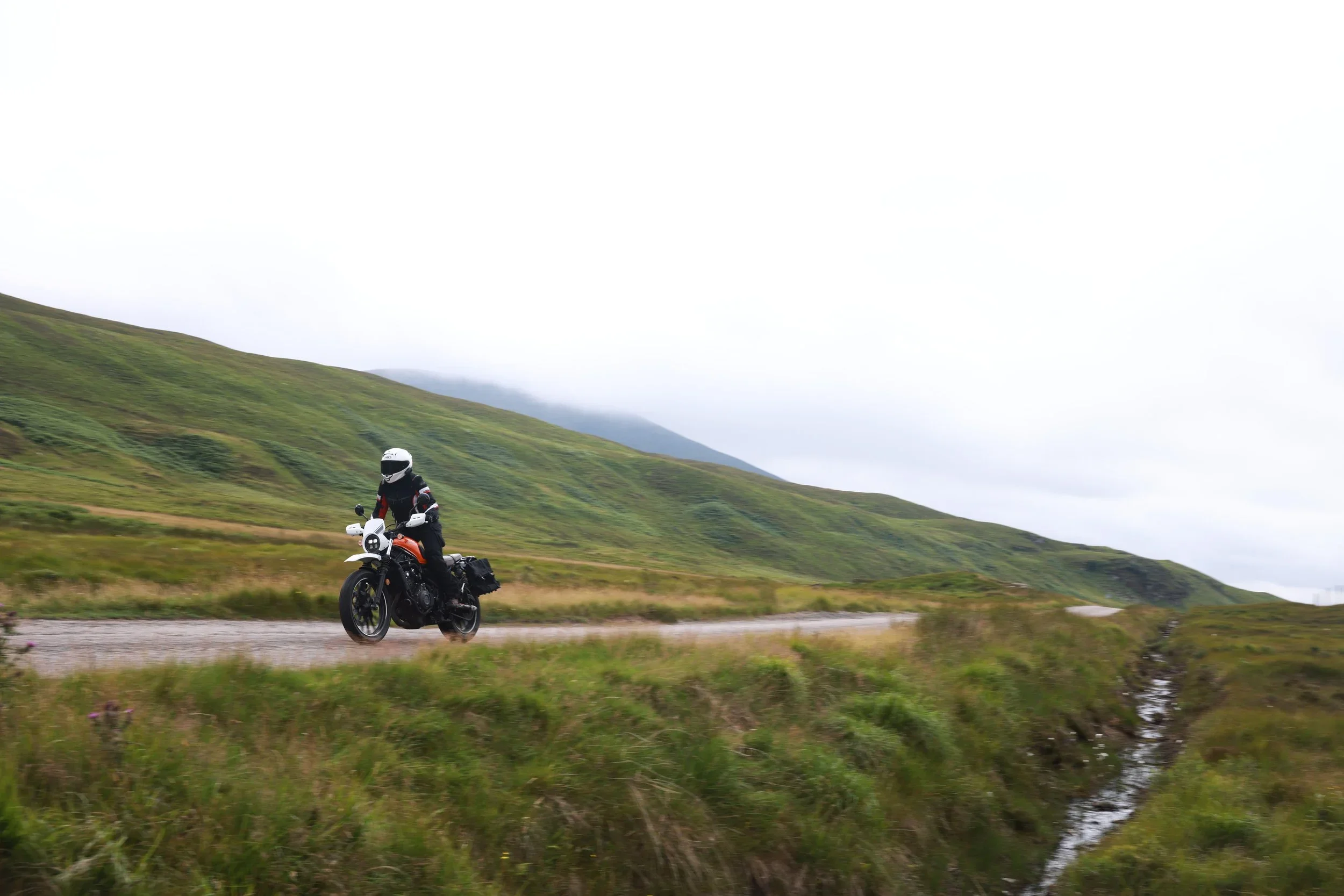 Girl riding trough nature on motorcycle standing