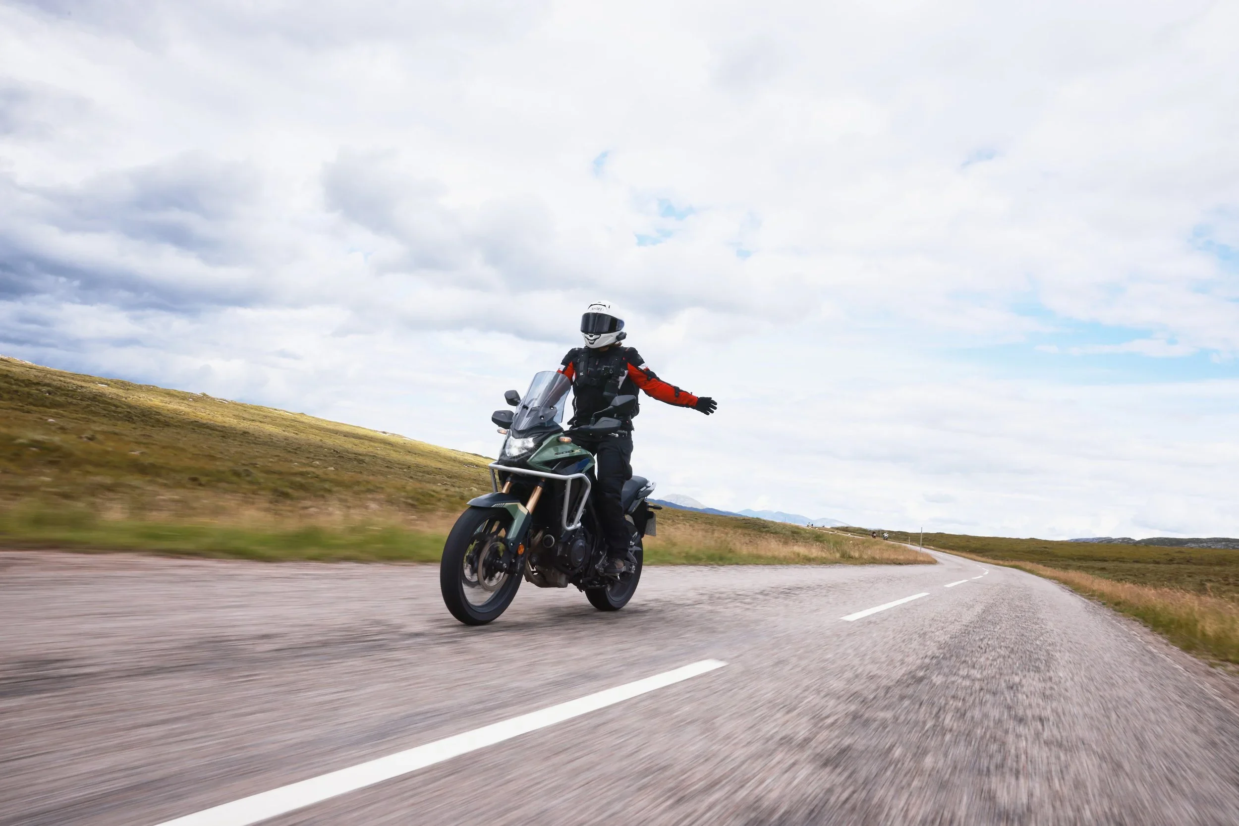 Girl feeling free on adventure bike on open road