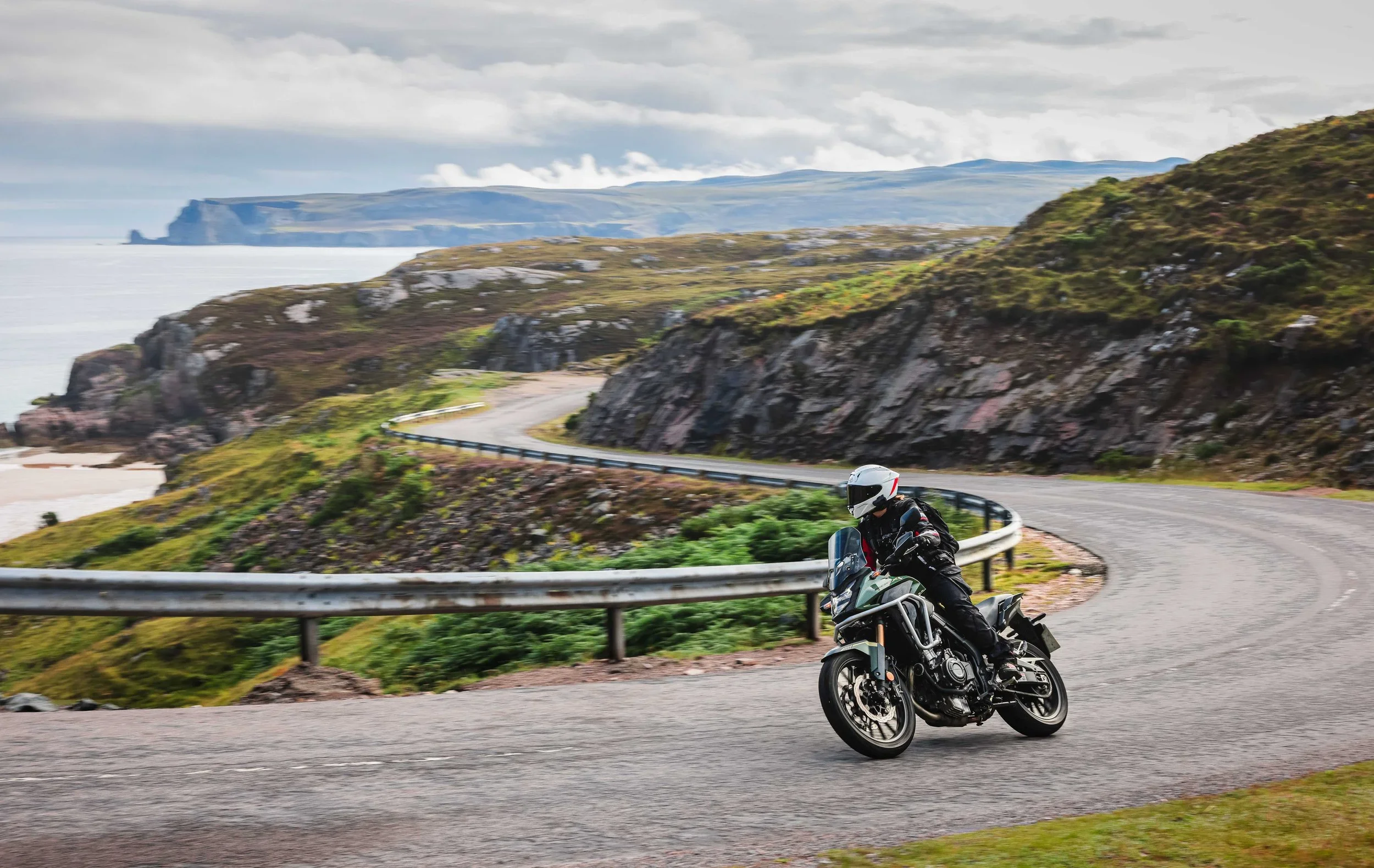 Girl riding adventure bike trough hils