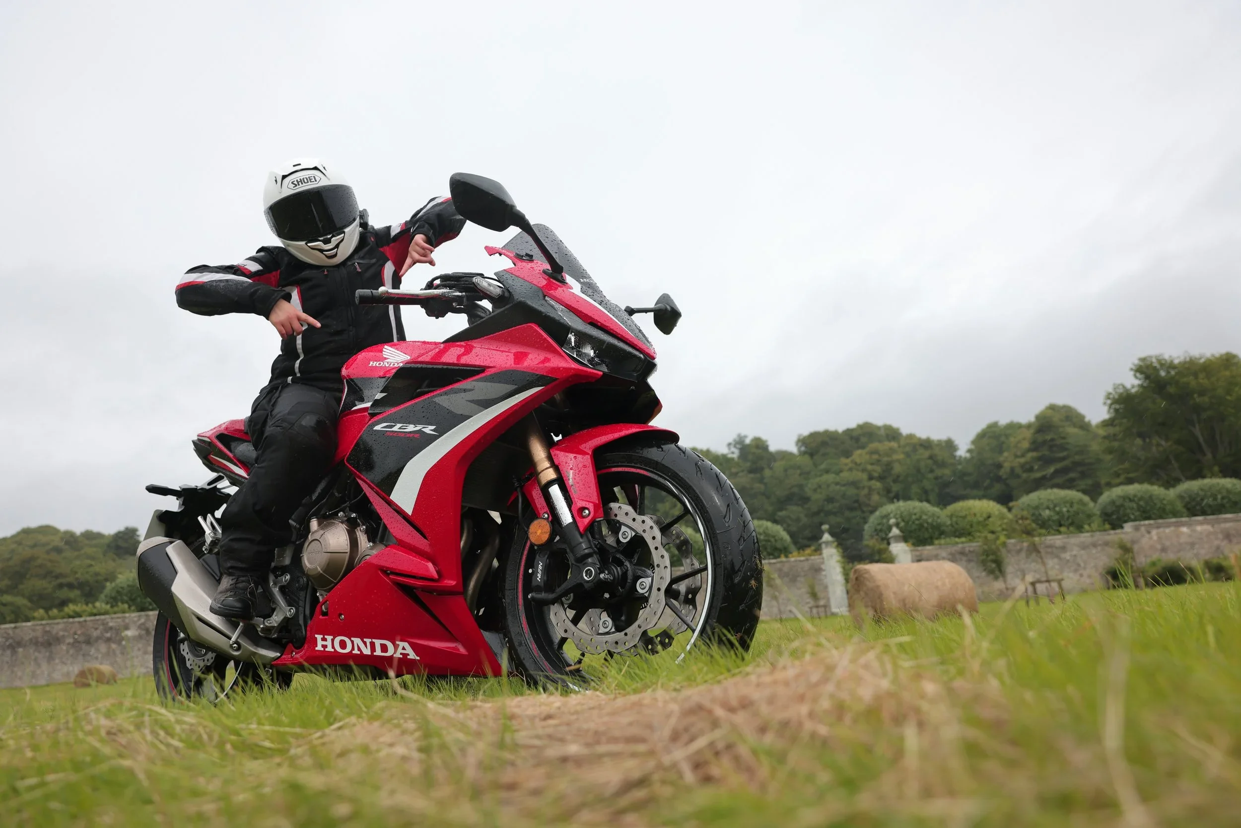 Girl sitting on supersport in rainy conditions