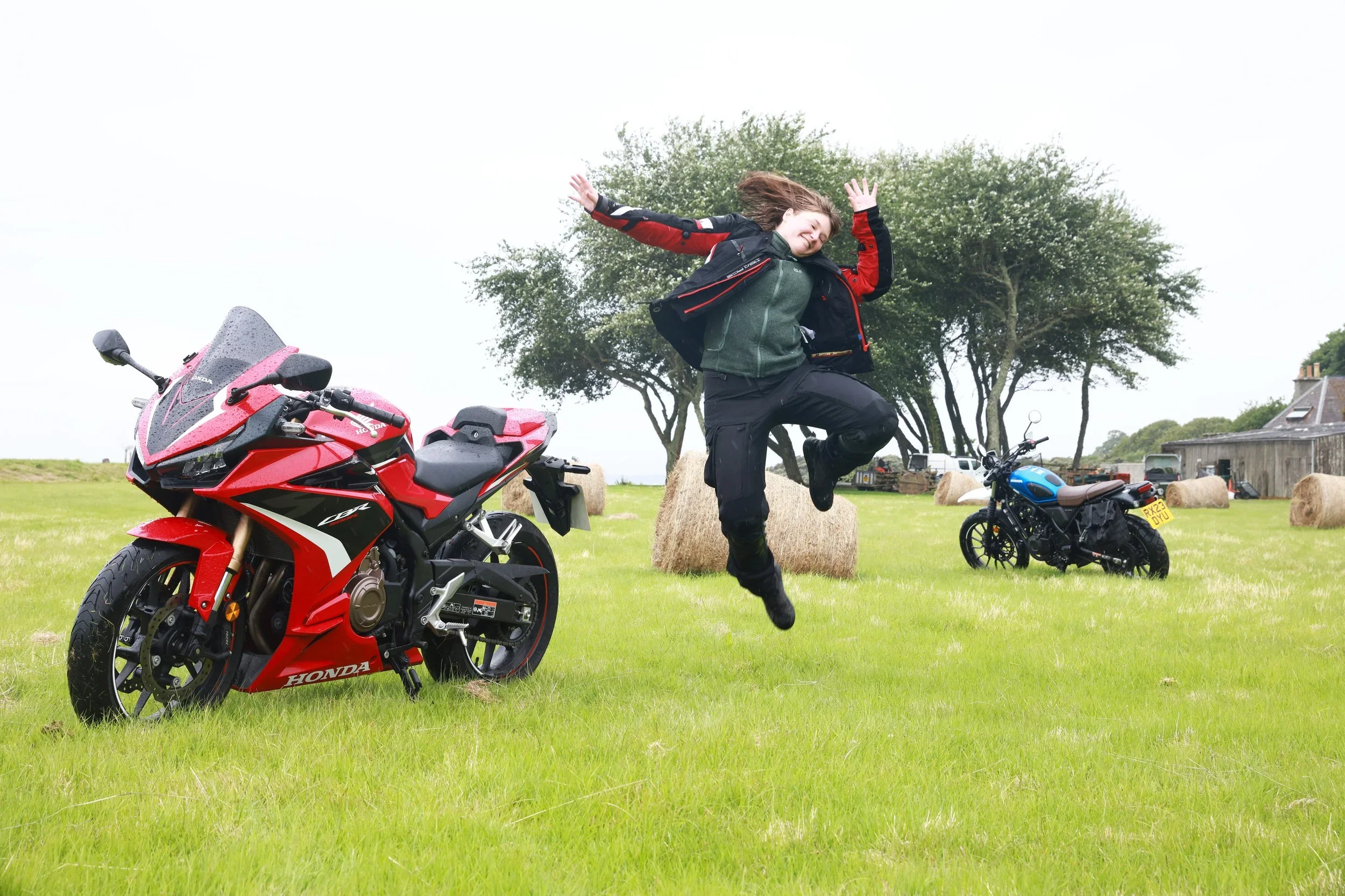 Girl happy, jumping in front of motorcycles