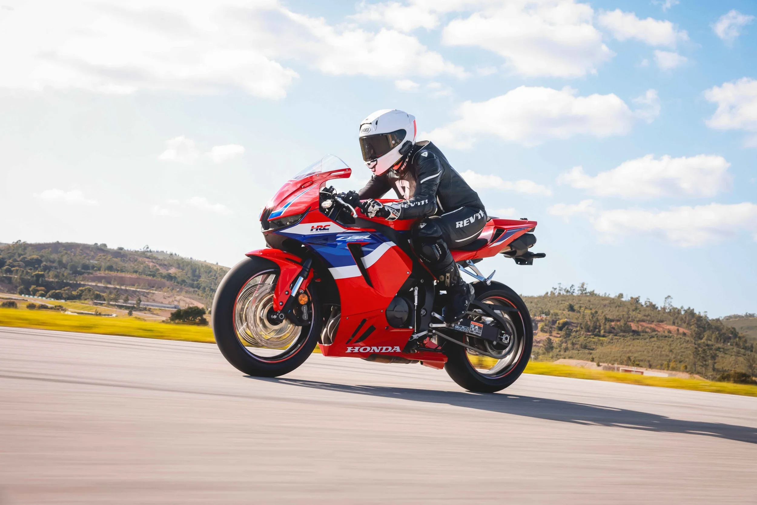 Woman riding red motorcycle at race track, bikesbyjane, jane duursma, CBR600RR 2024, Rev'it onepiece, shoei X-spr pro, HRC, Cardo, Portimao