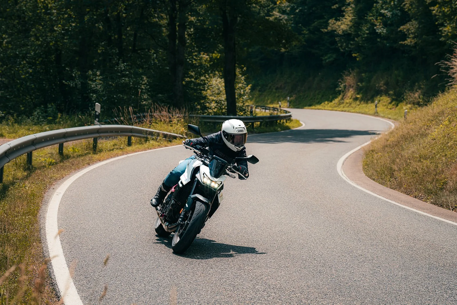 Honda CB750 Hornet 2025 met Quickshifter op mooi bochtig weggetje met veel bomen en groen