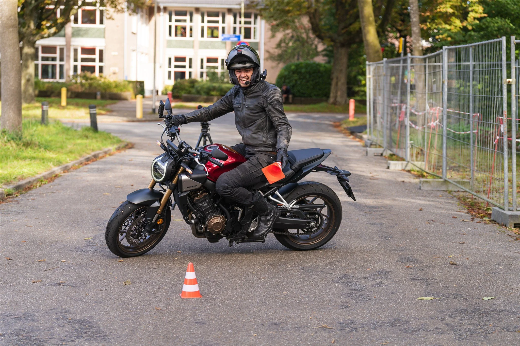 Person riding Honda CB650R with E-Clutch holding a cone practicing for motorcycle exam