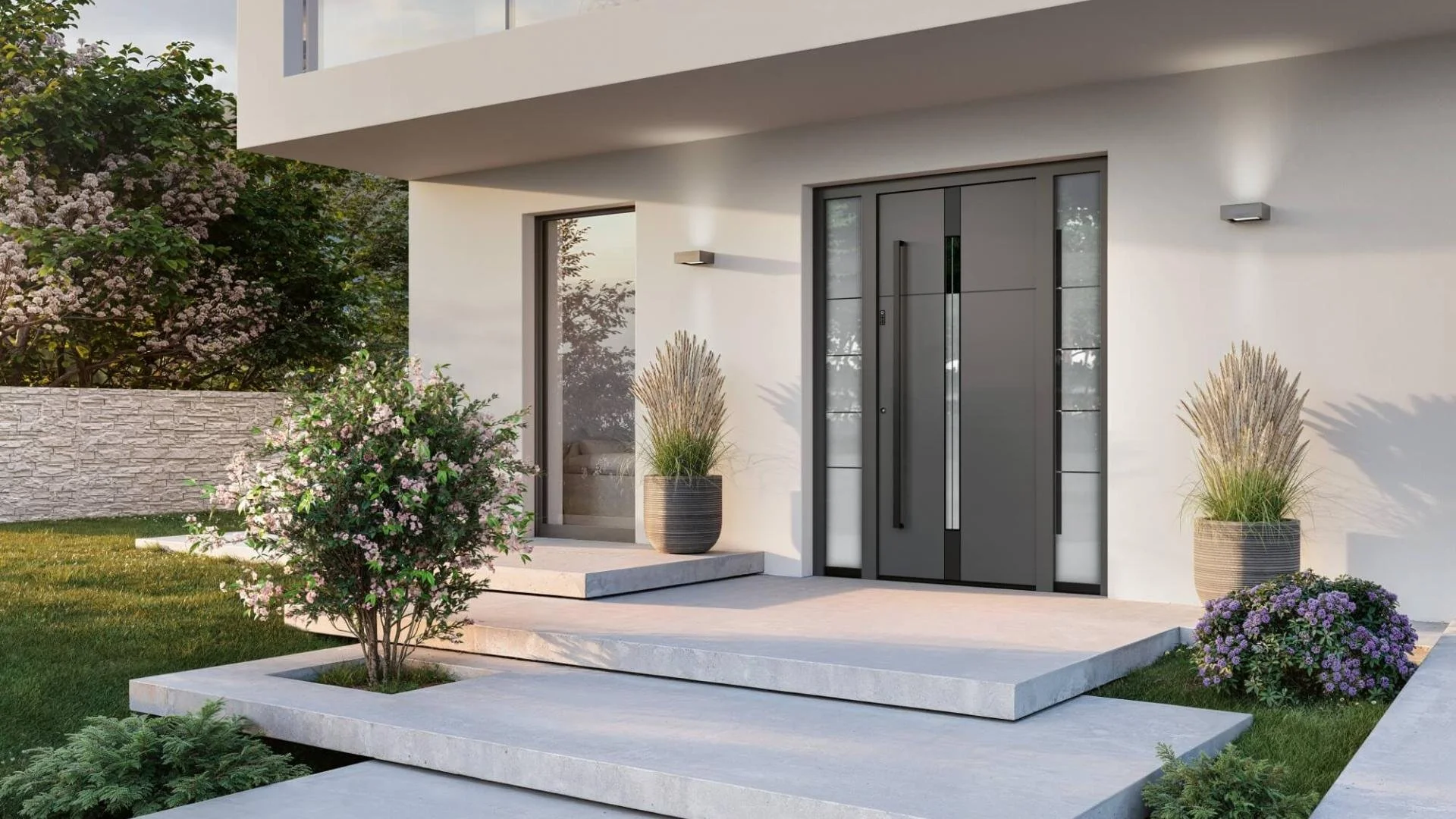 Modernes Zuhause mit großem weißen Eingang, grauer Tür, bepflanztem Vorgarten, Blumen und Büschen