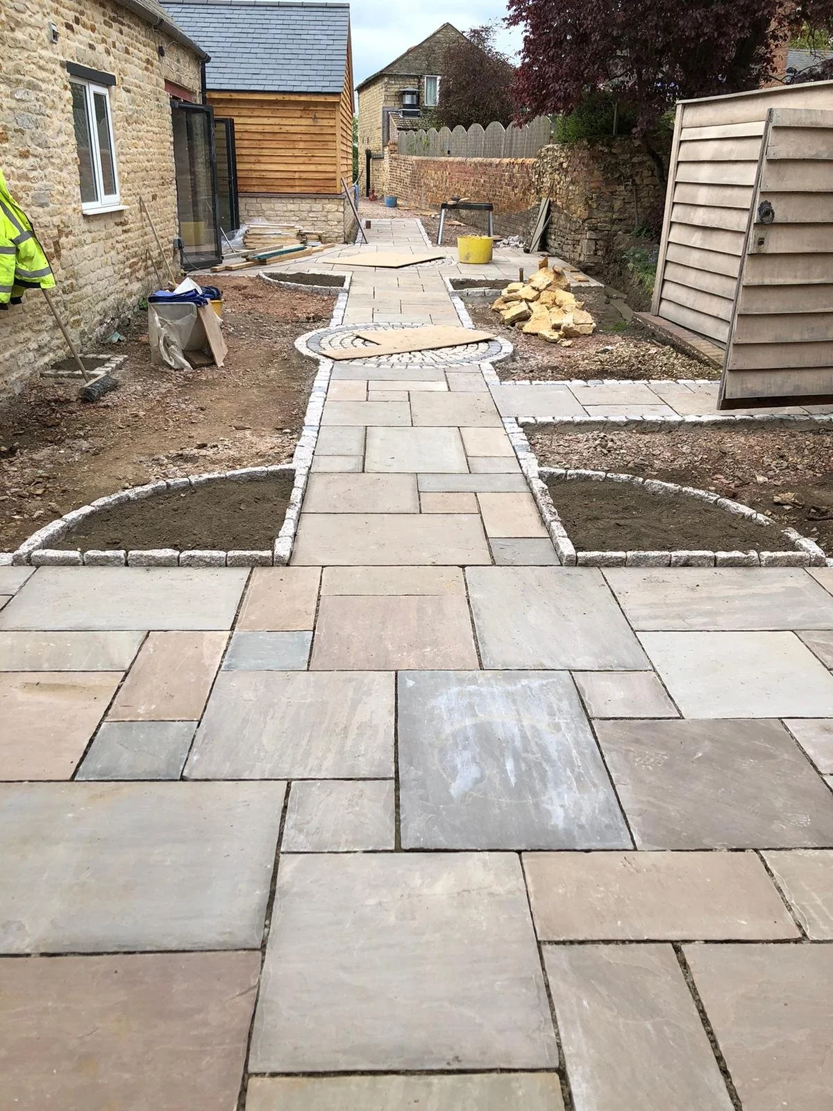 Under construction backyard patio with paving stones and garden beds completed by local Grantham builder G East Builder.