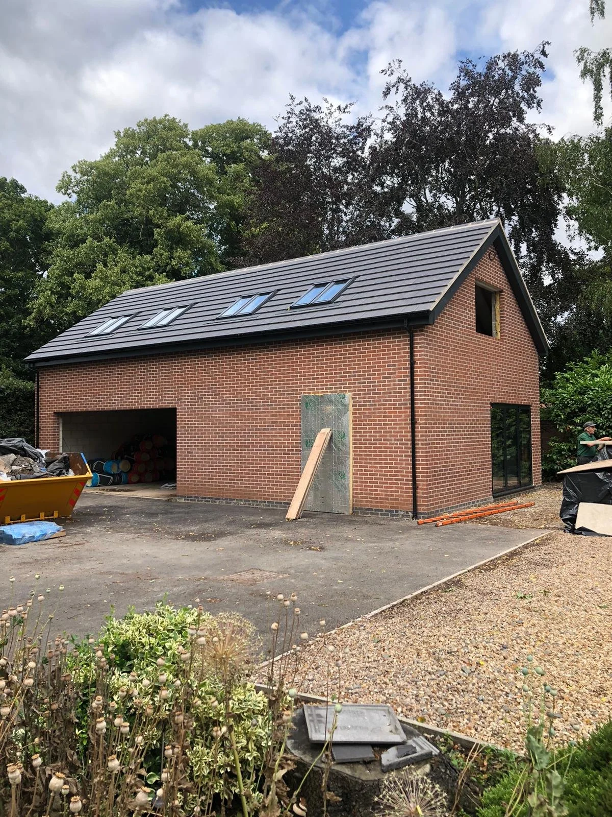 New brick garage building under construction with a sloped roof and skylights completed by local Grantham builder G East Builder.