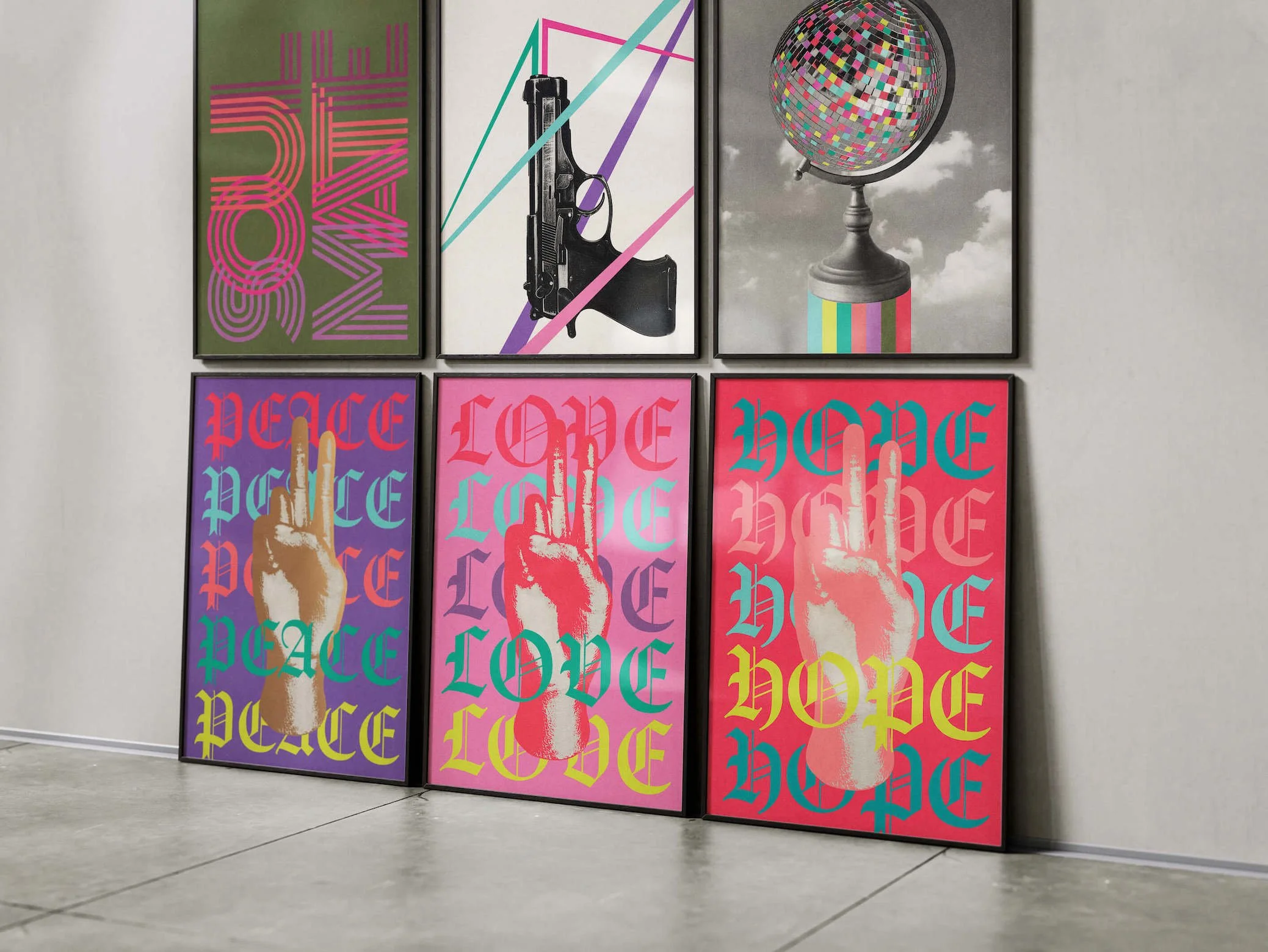 Six colorful pop artworks by Paul Scott leaning against a wall.