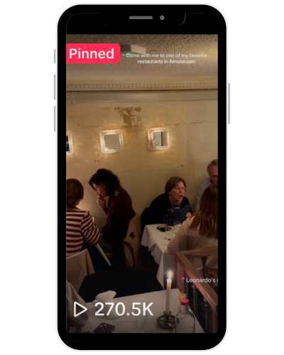 Mobile phone screen displaying a TikTok video of a restaurant scene with several seated patrons, candles on tables, and a faintly distressed wall with three small square windows. The video has over 270,000 views and a red 'Pinned' label at the top.