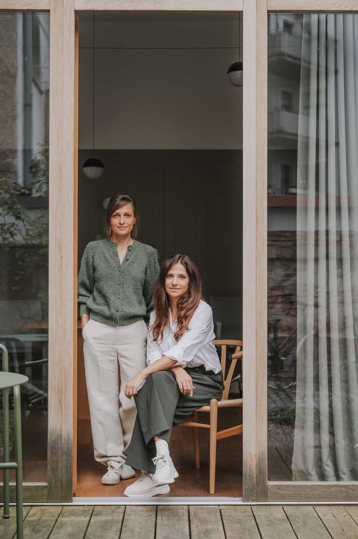 Zwei Innenarchitektinnen in einem minialstischen, natürlichen Interieur. Hochwertige und natürliche Materialien, harmonisch gewählte Farben und zeitloses Design spiegeln ihren architektonischen Stil wider.
