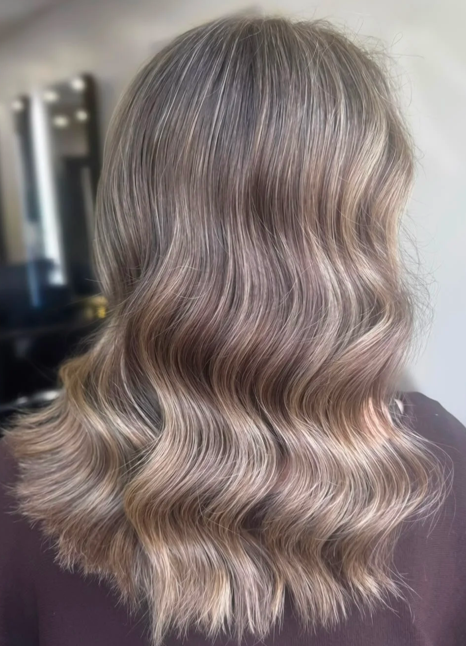 Shoulder-length balayage with soft waves, showing seamless colour blending and a glossy finish.
