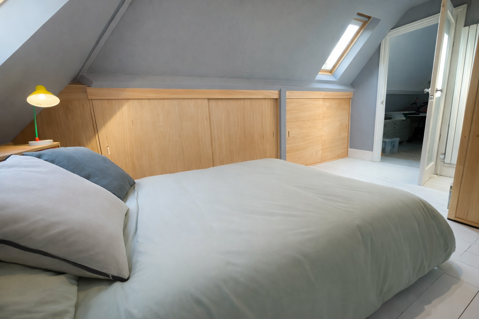 Fitted Bedroom Storage: 
Sliding door storage areas built into eaves with natural plywood
