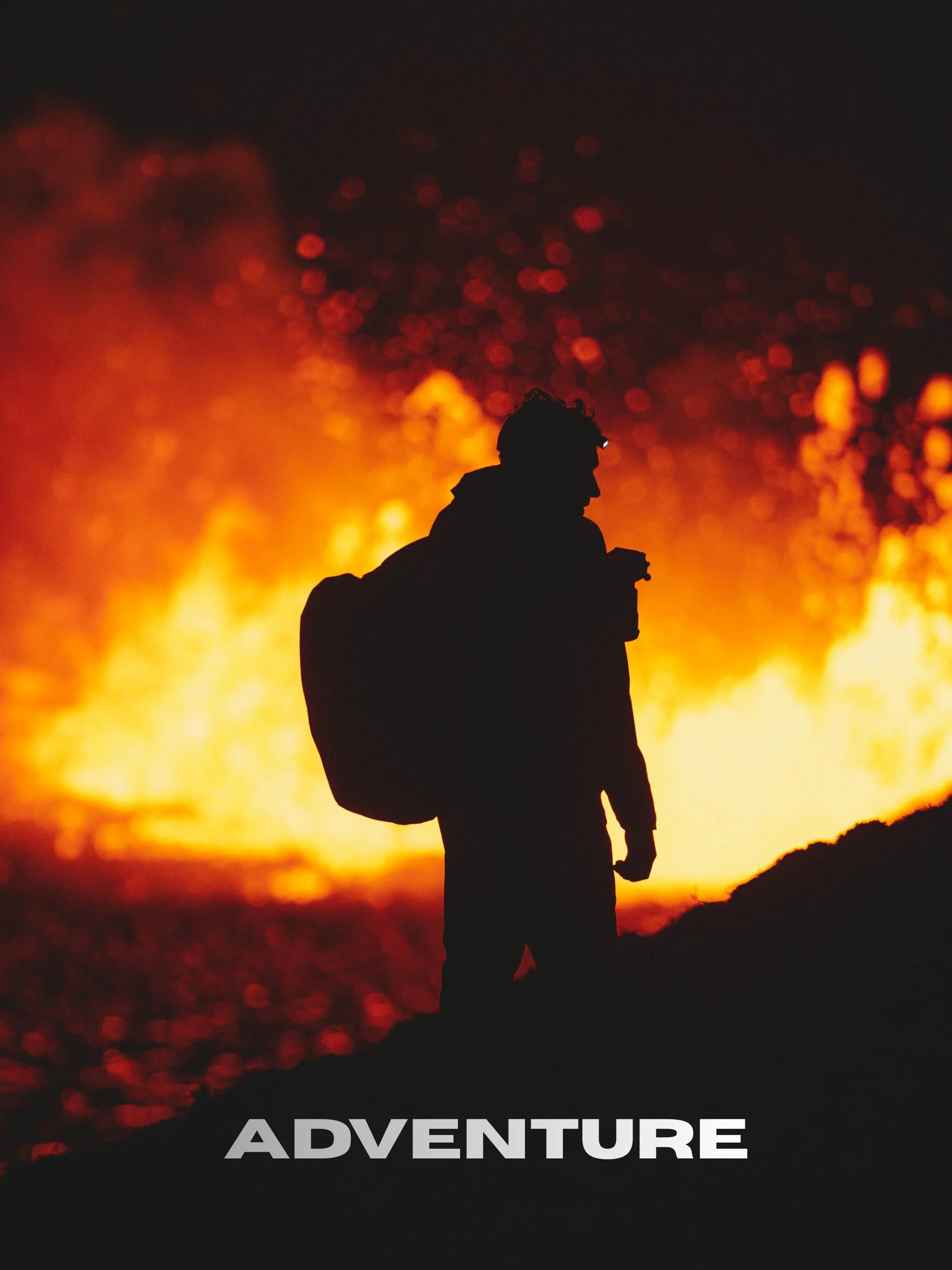 Silhouette of a person with a backpack standing on a hilltop silhouetted against a large fiery explosion or fire in the background, with the word 'ADVENTURE' in bold gray letters at the bottom.
