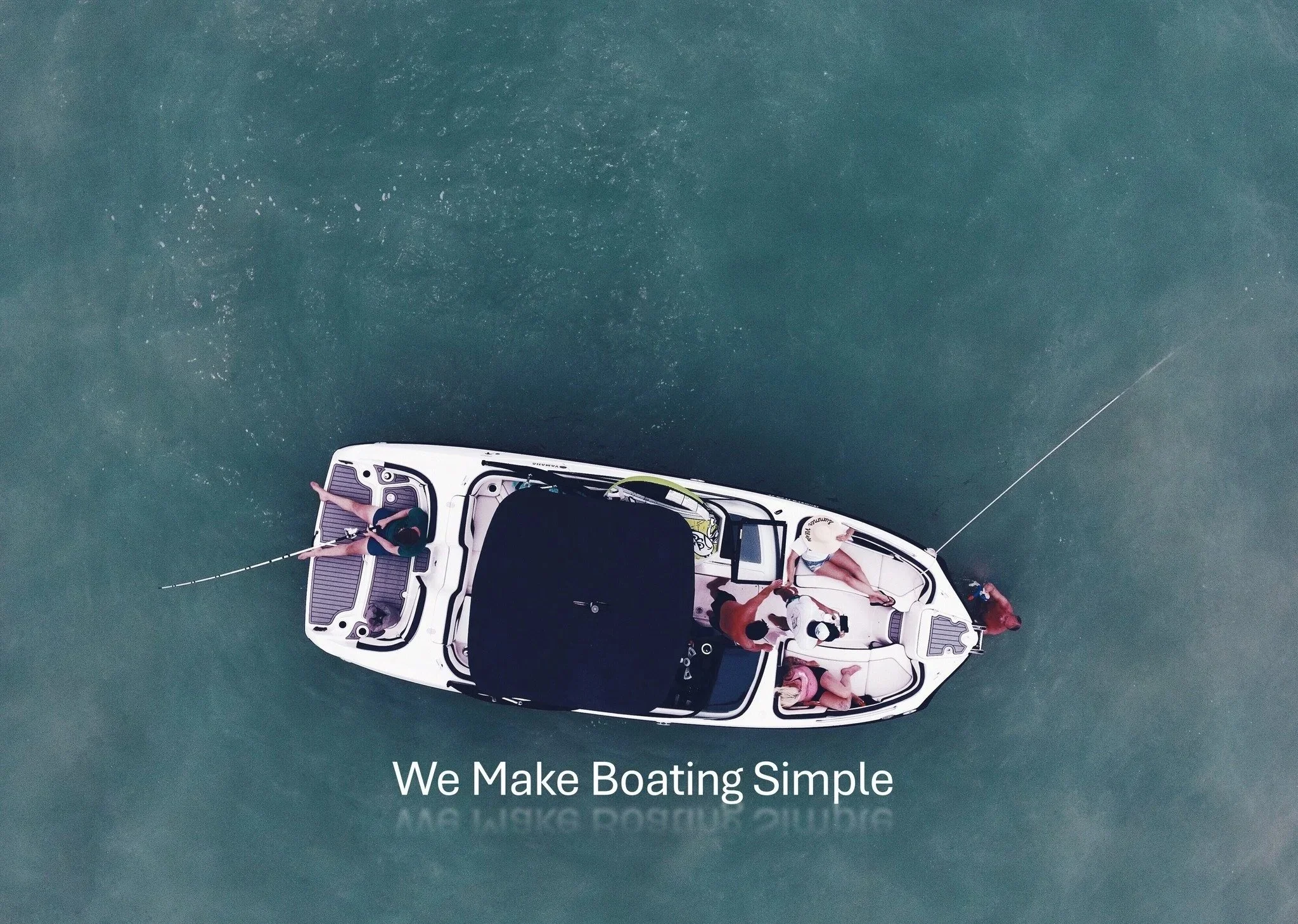 Overhead view of a boat with four people on board, two standing and two sitting, fishing in calm water. Text overlay reads 'We Make Boating Simple'.