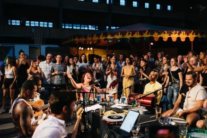 SambaRoots live Brazilian music performance at an outdoor festival with a diverse audience watching and enjoying the show.
