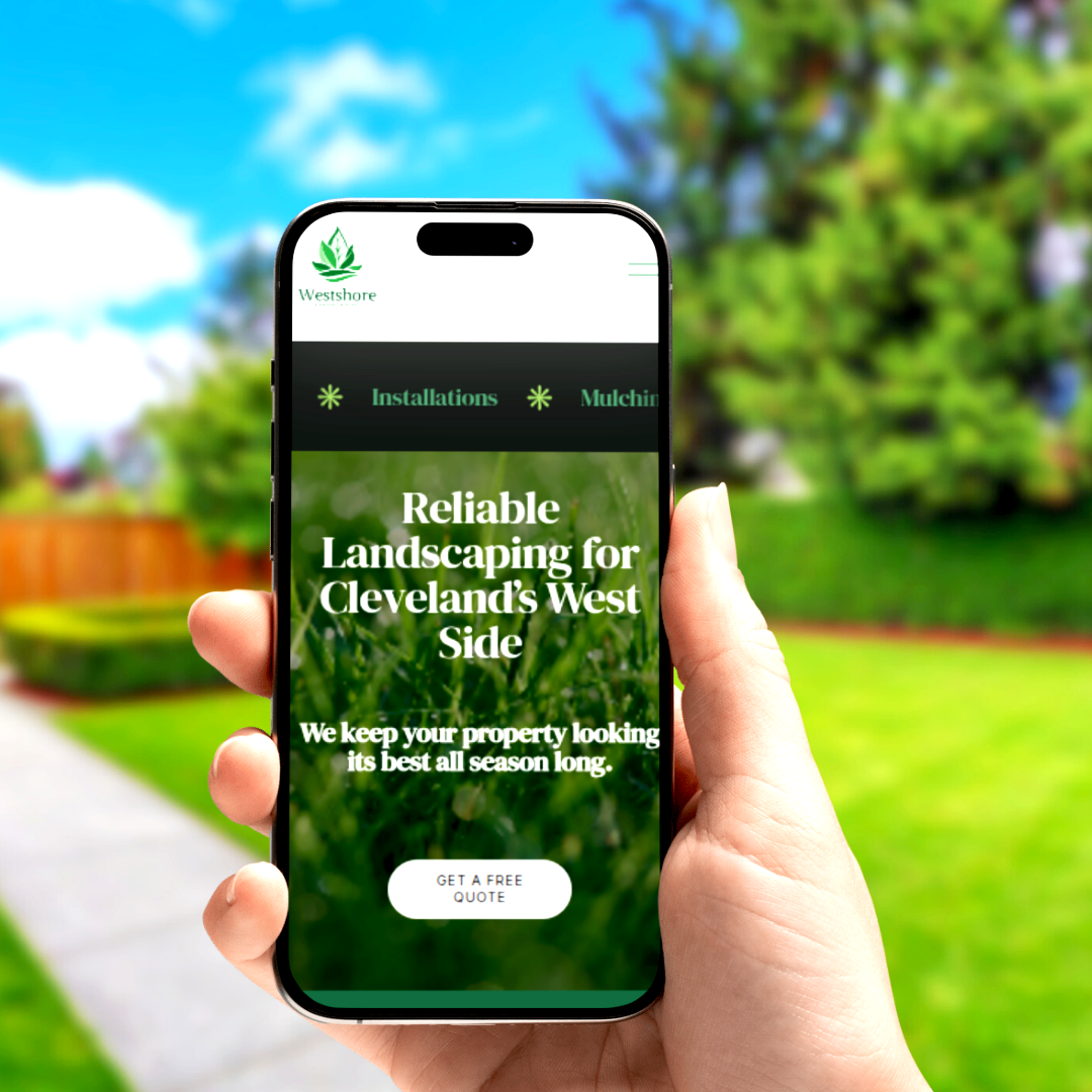 Hand holding smartphone displaying landscaping services website in a backyard with a green lawn, trees, blue sky, and a wooden fence.