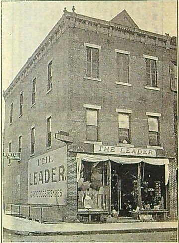 Front view of a 3 story building with The Leader sign above front door