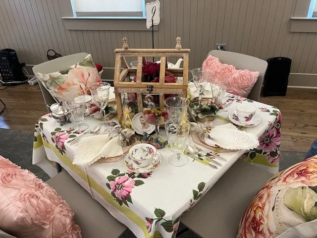 Table decorated with pink flowers and pink cushions on the seats