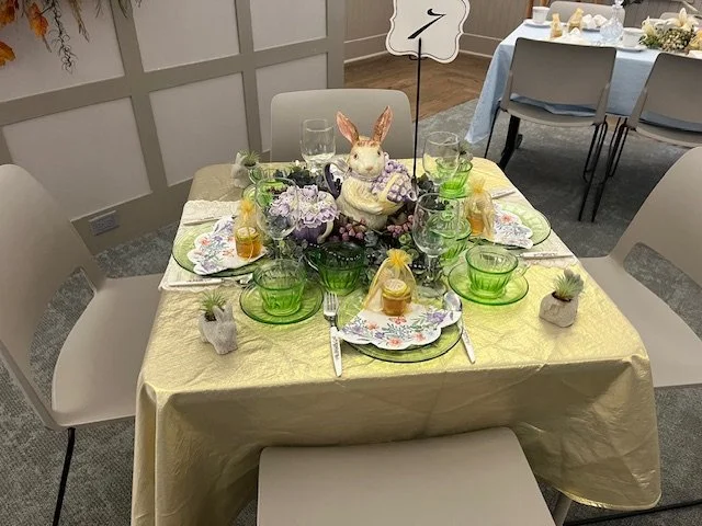 Table with yellow table cloth and green settings with a bunny centerpiece