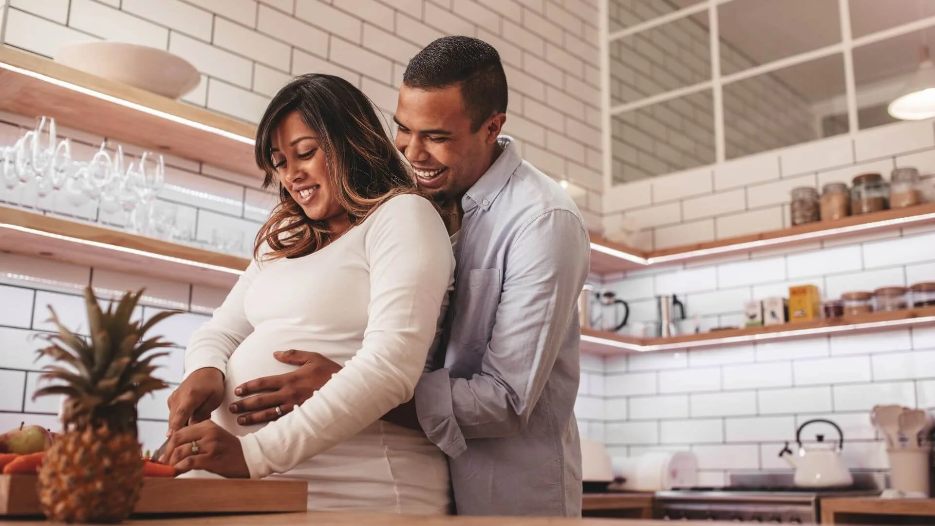 a pregnant wife and husband making healthy meals