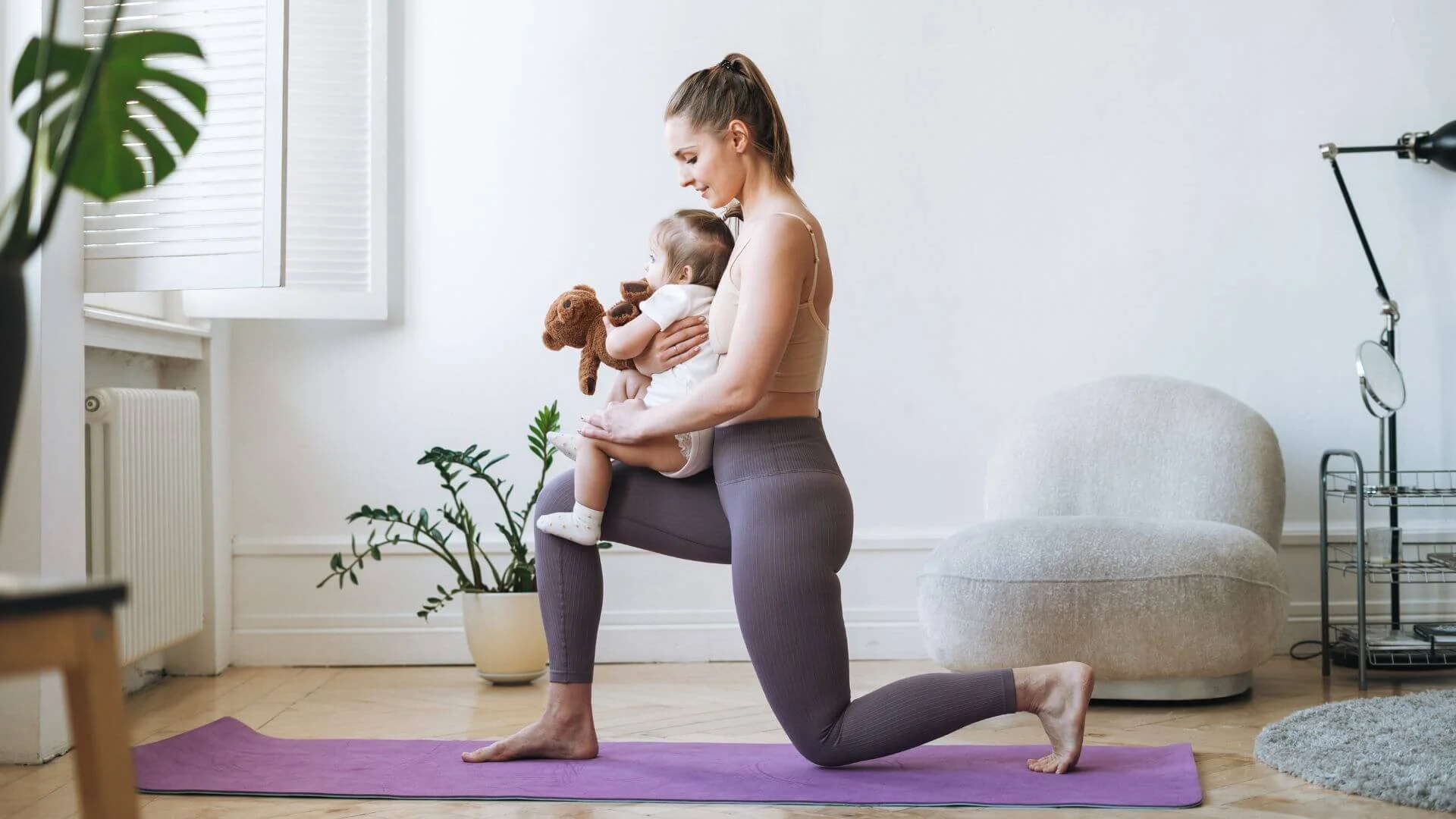 new mother doing an exercise with her baby