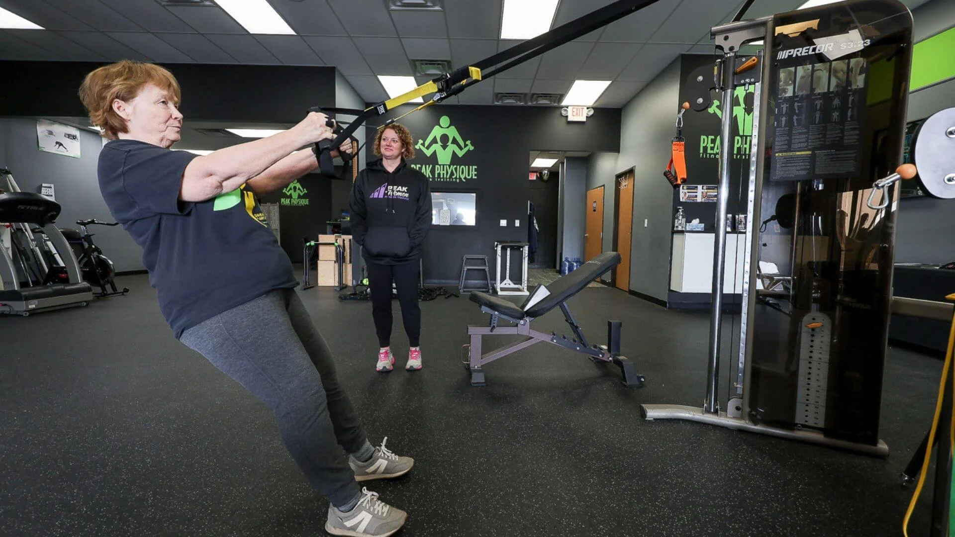 Lissa watching a client train at personal training gym
